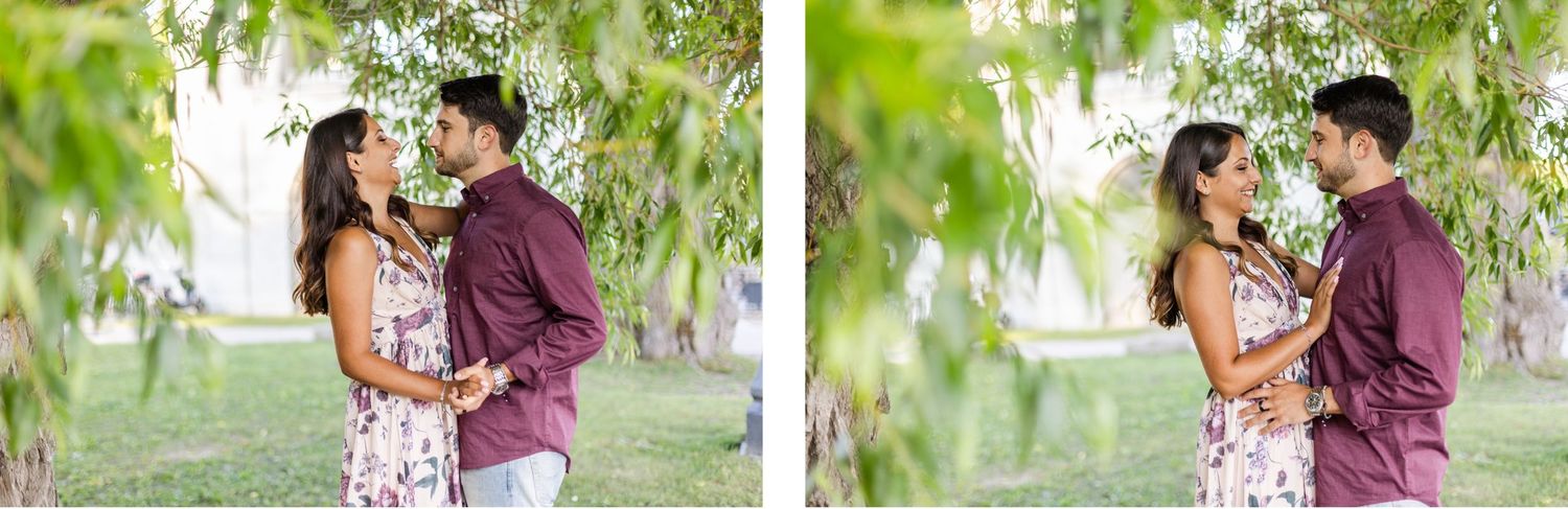 Romantic couple embracing under green willow branches in coordinated outfits.