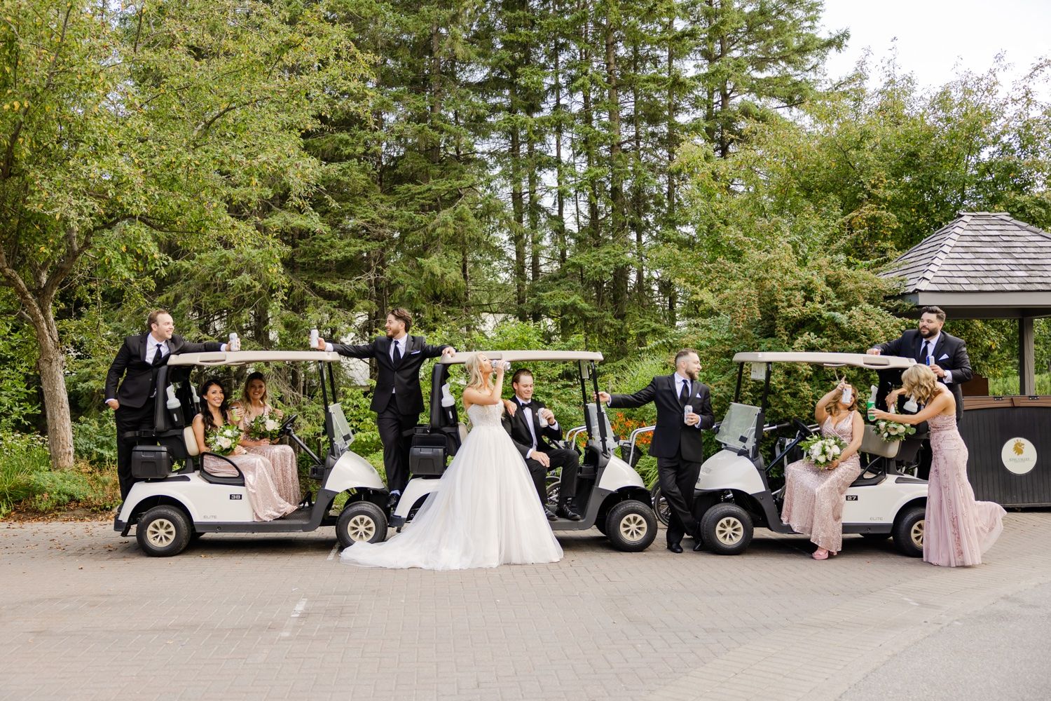 Bridal party with golf carts lined up at an elegant outdoor wedding venue.