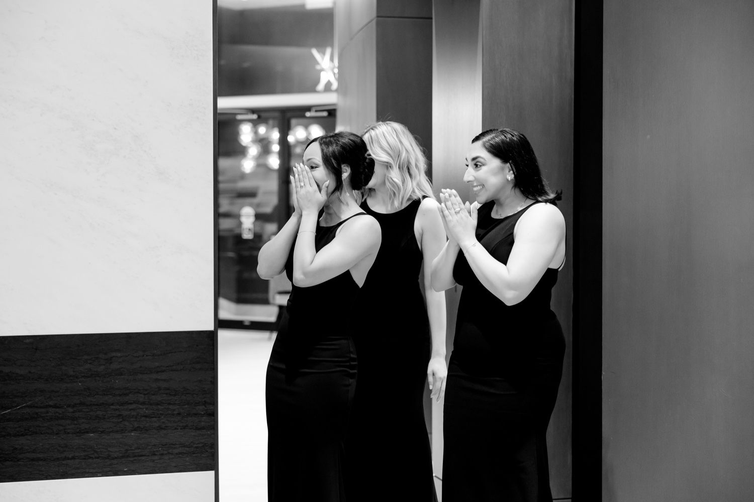 Wedding party members react with joy and tears during emotional first look.