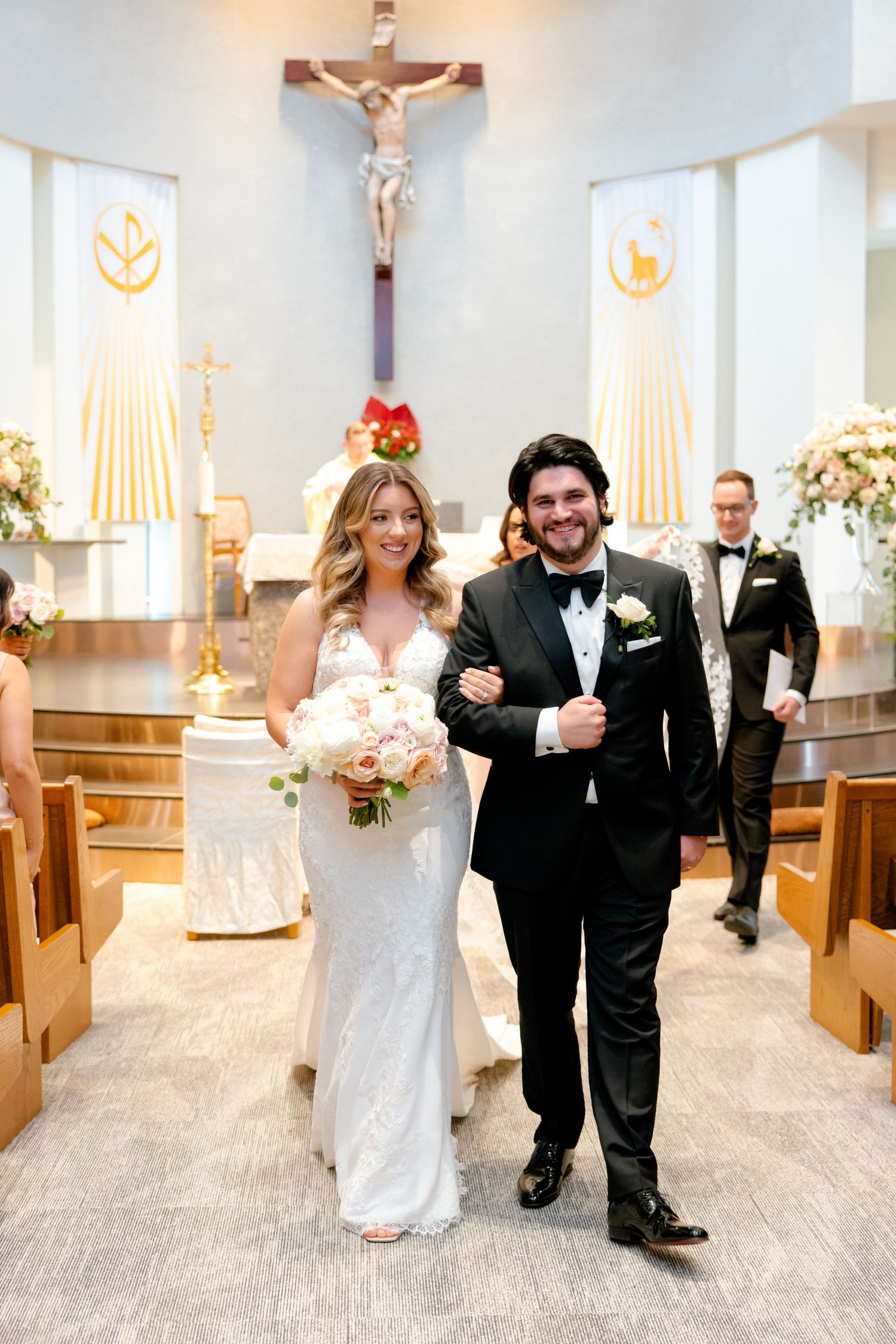 Joyful couple walking down the church aisle after their wedding ceremony.