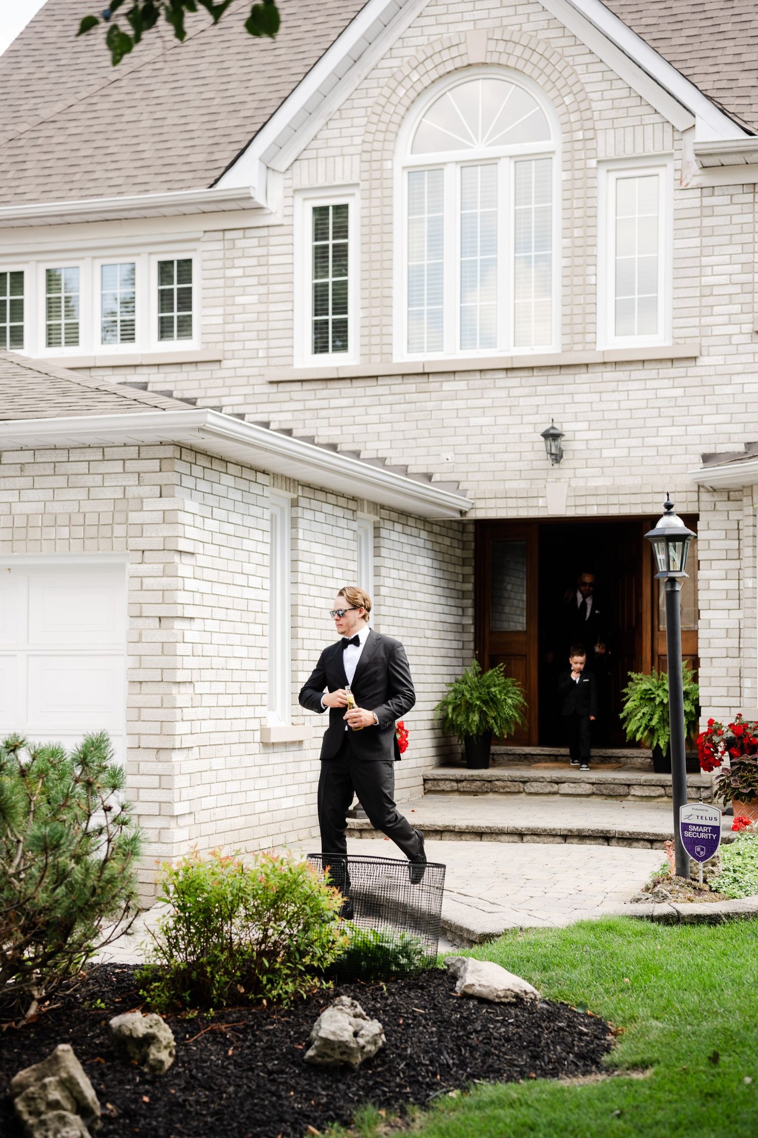 Classic white brick house exterior with arched window and landscaped entrance.