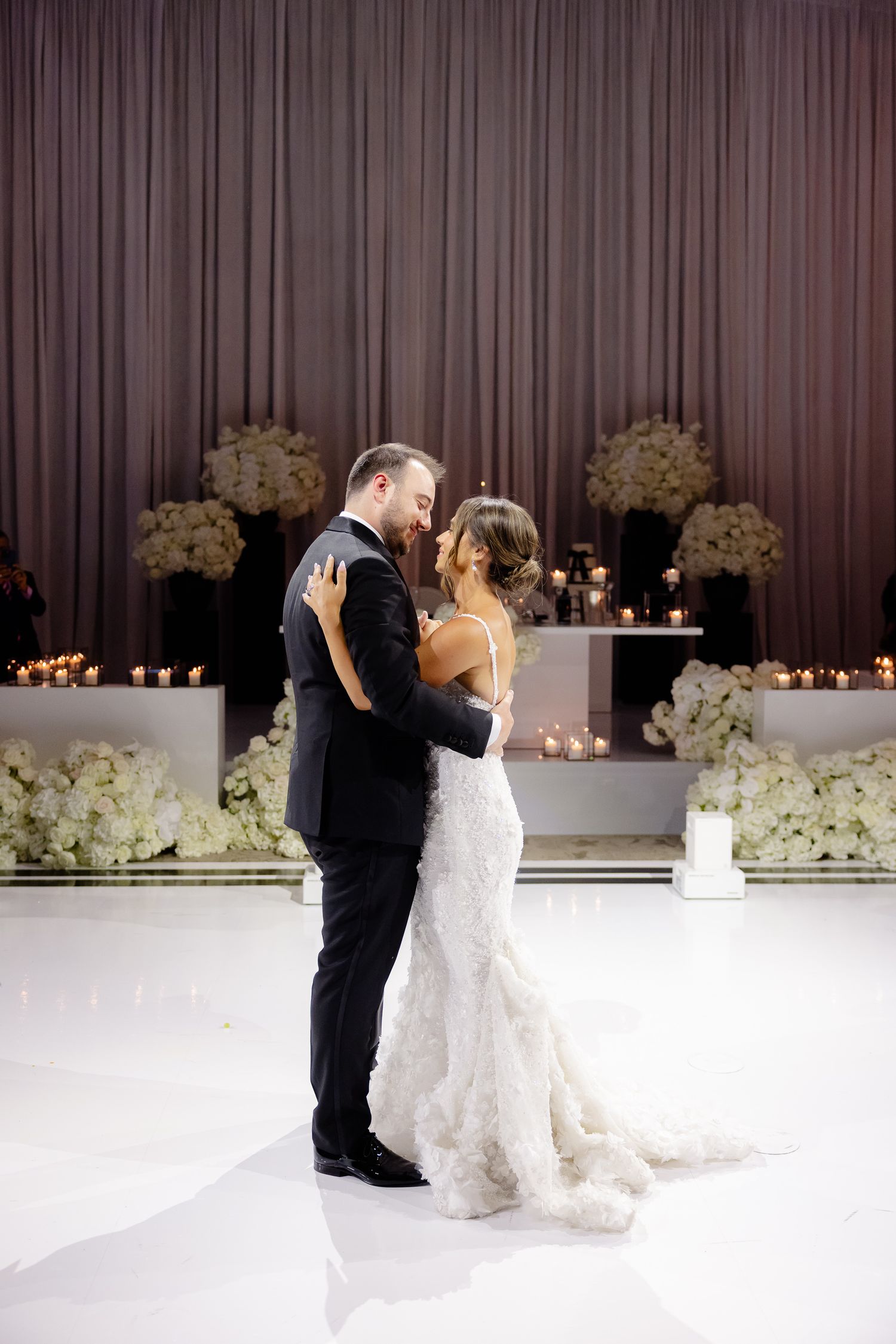 A series of romantic wedding dance sequence photos captured against a backdrop of white florals and curtains.