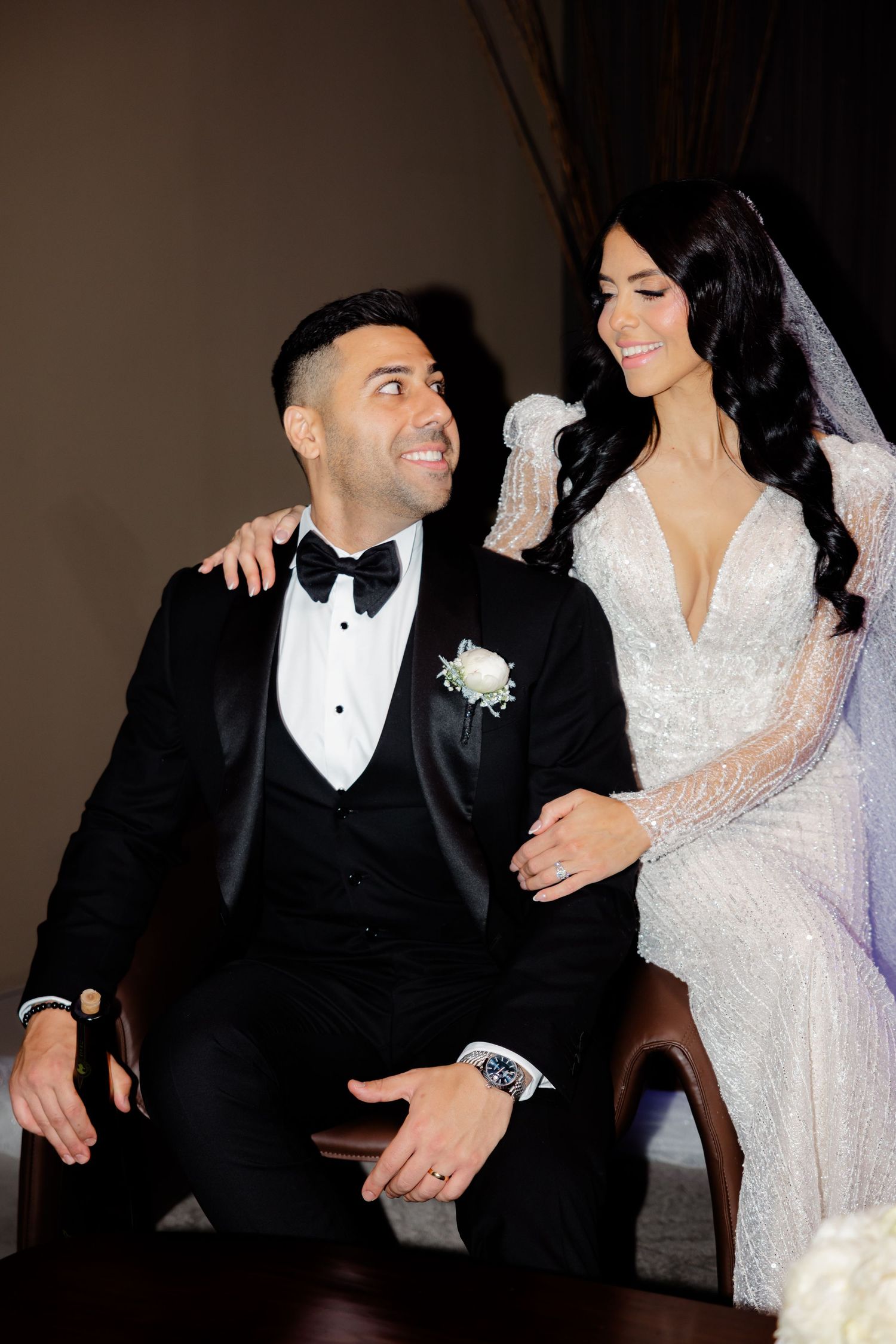 Joyful wedding couple shares intimate moment during formal portrait session.