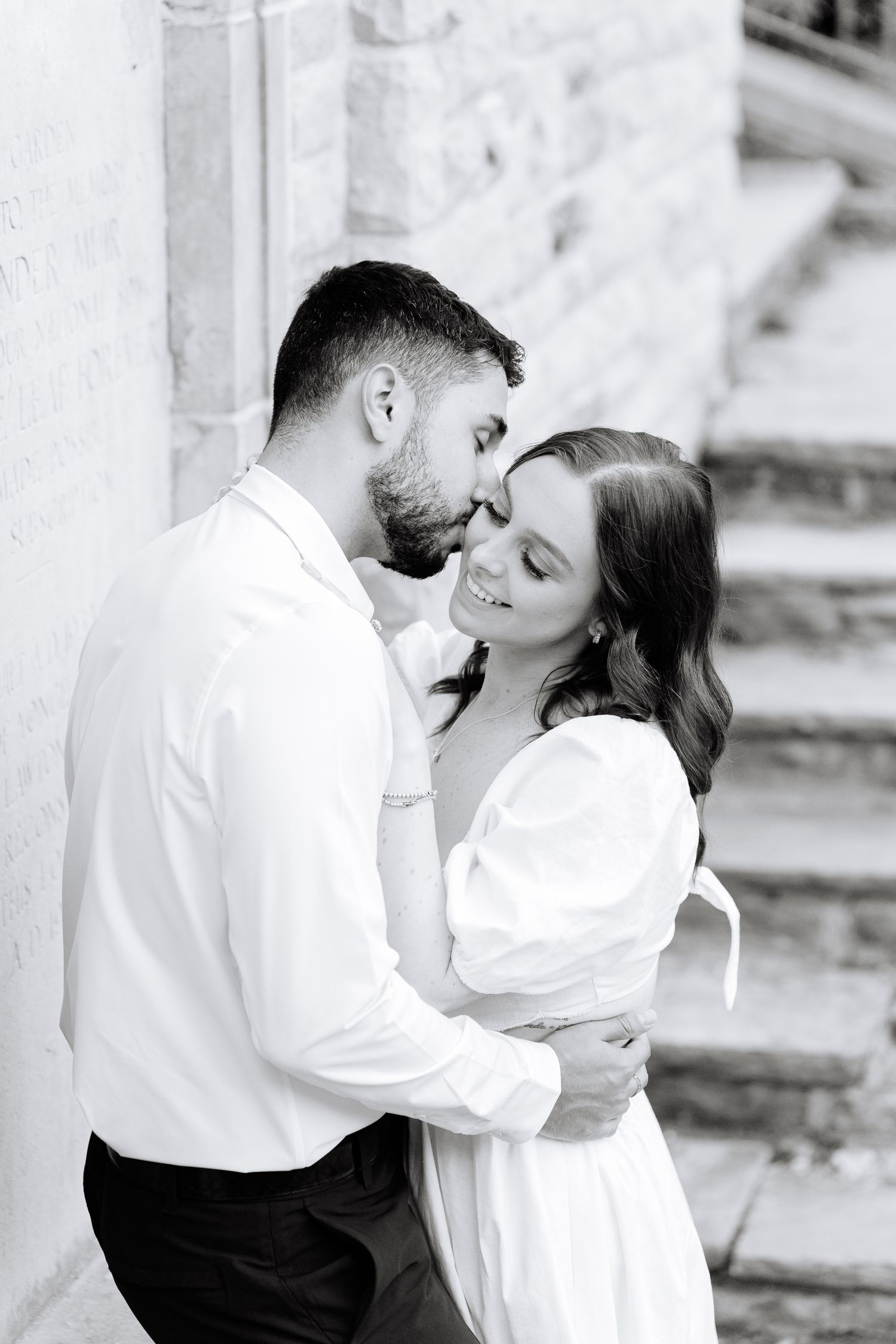 A romantic black and white portrait of a couple sharing an intimate moment.