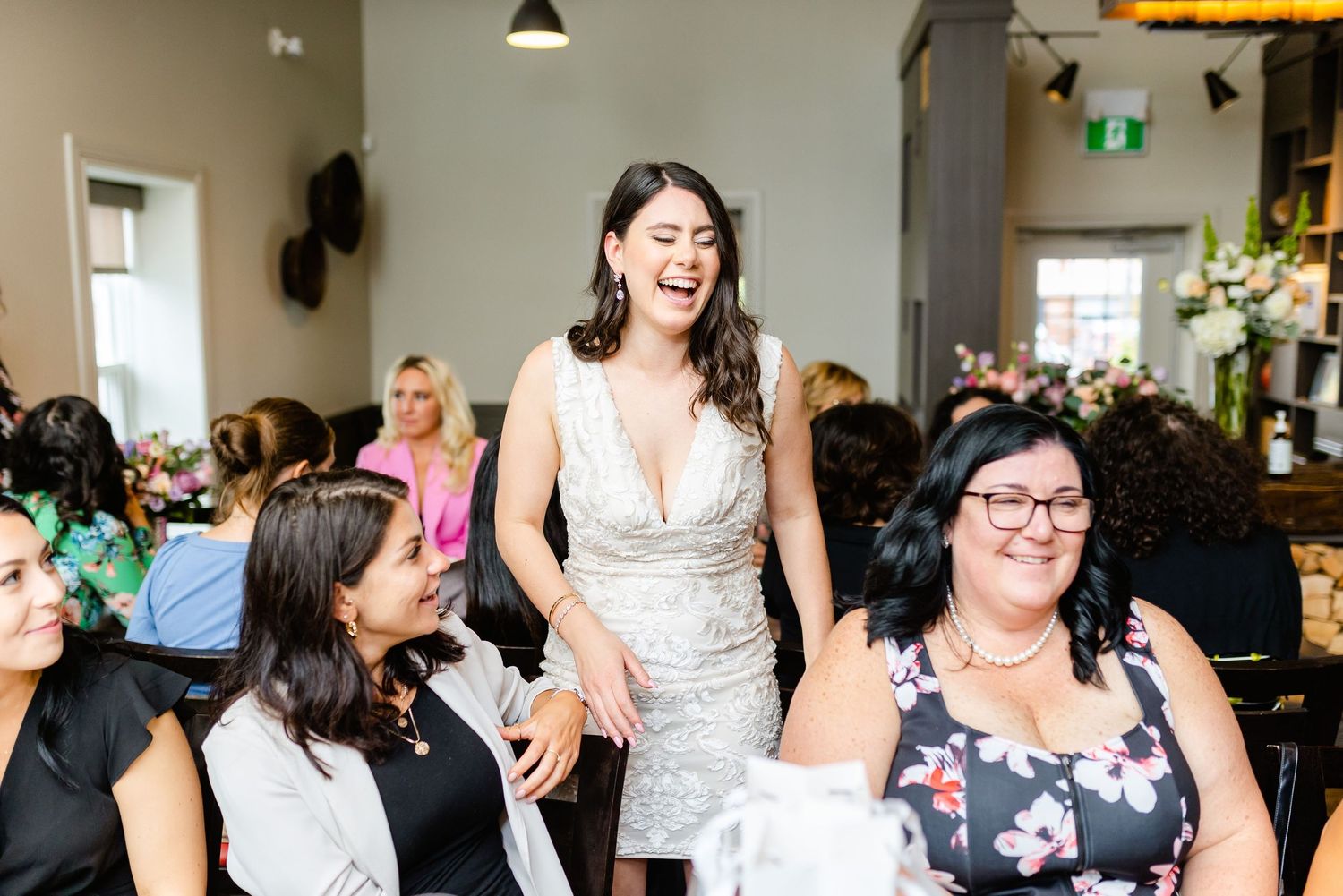A group celebrates in a modern restaurant during a brunch gathering with laughter and joy.