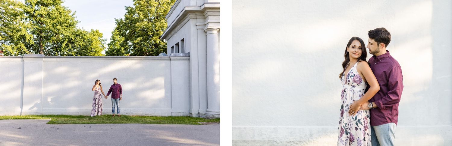 Wide architectural shot showing couple in coordinated outfits against white building exterior.