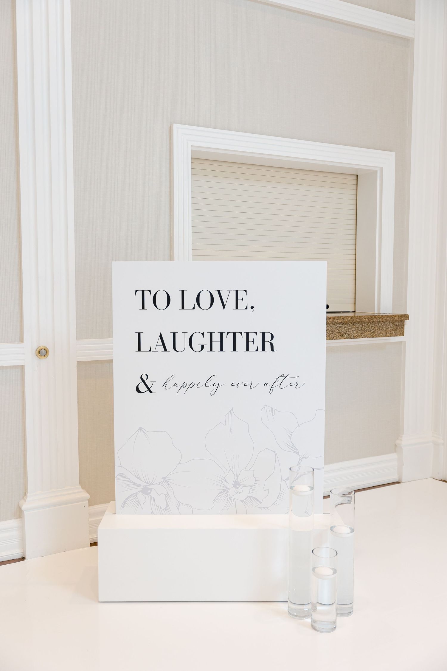 Elegant wedding sign with 'To Love, Laughter & Happily ever after' text on marble background.