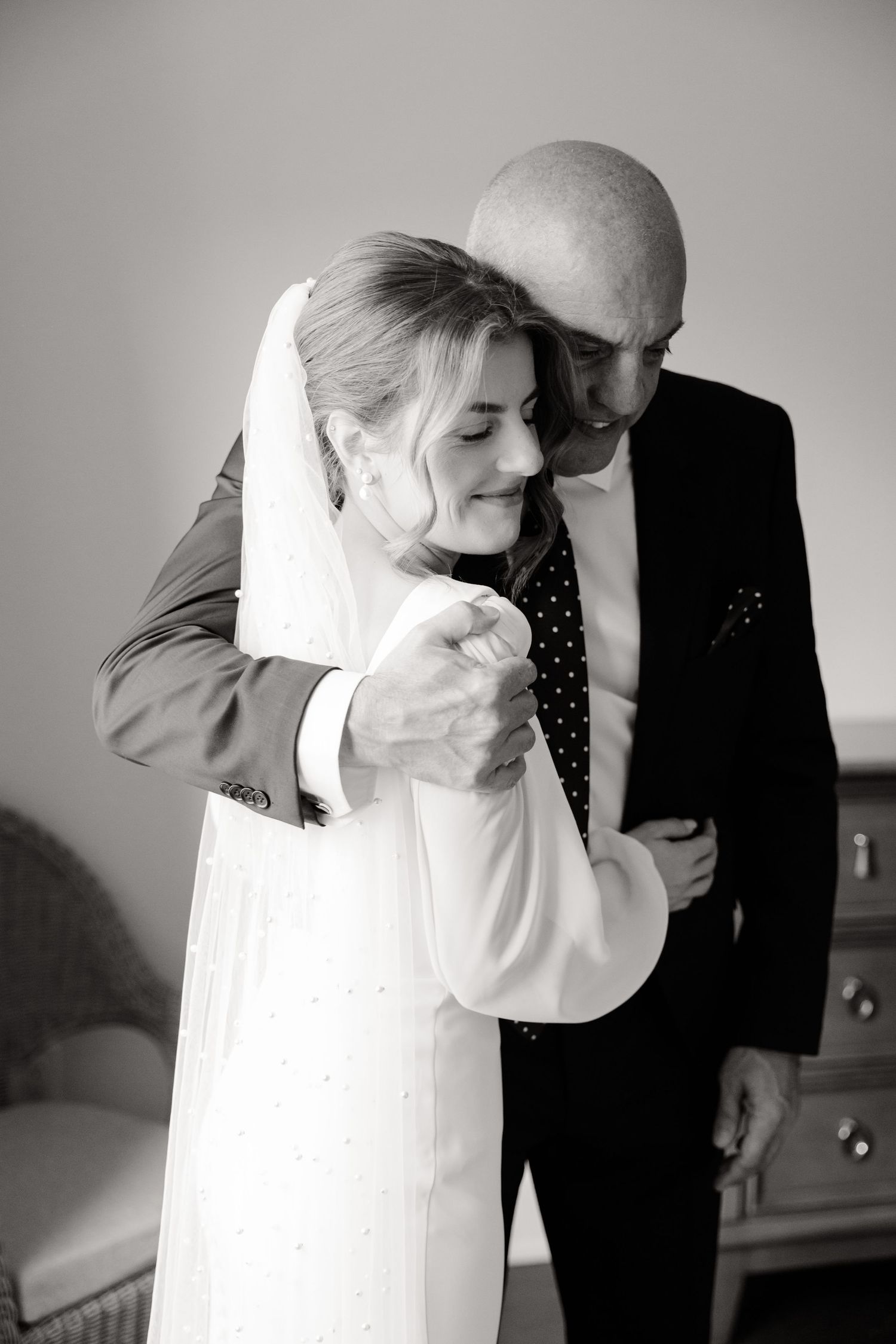 Black and white emotional wedding portrait with tender embrace.