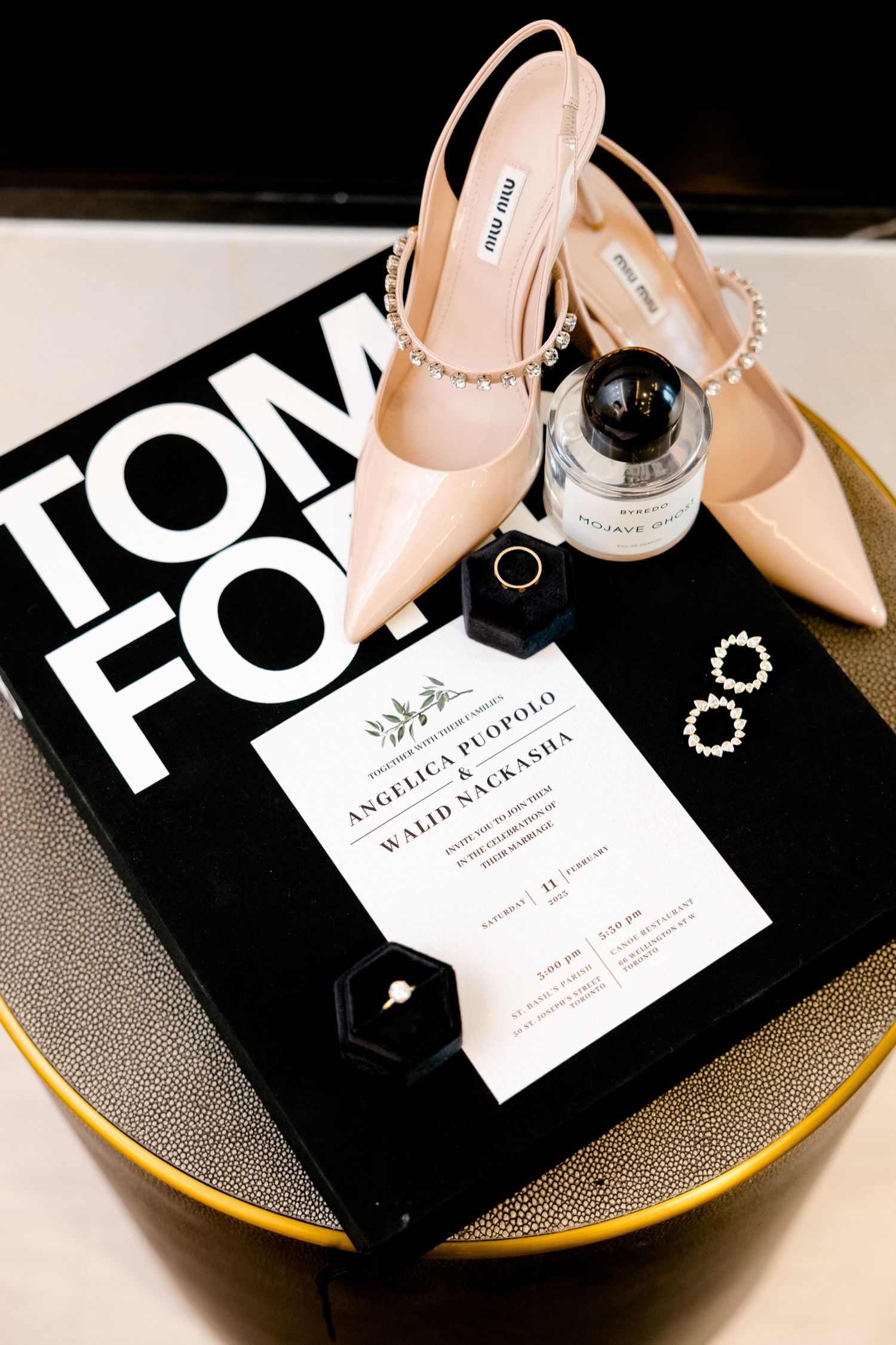 Elegant nude slingback heels with rhinestones displayed with wedding invitation and Tom Ford book.