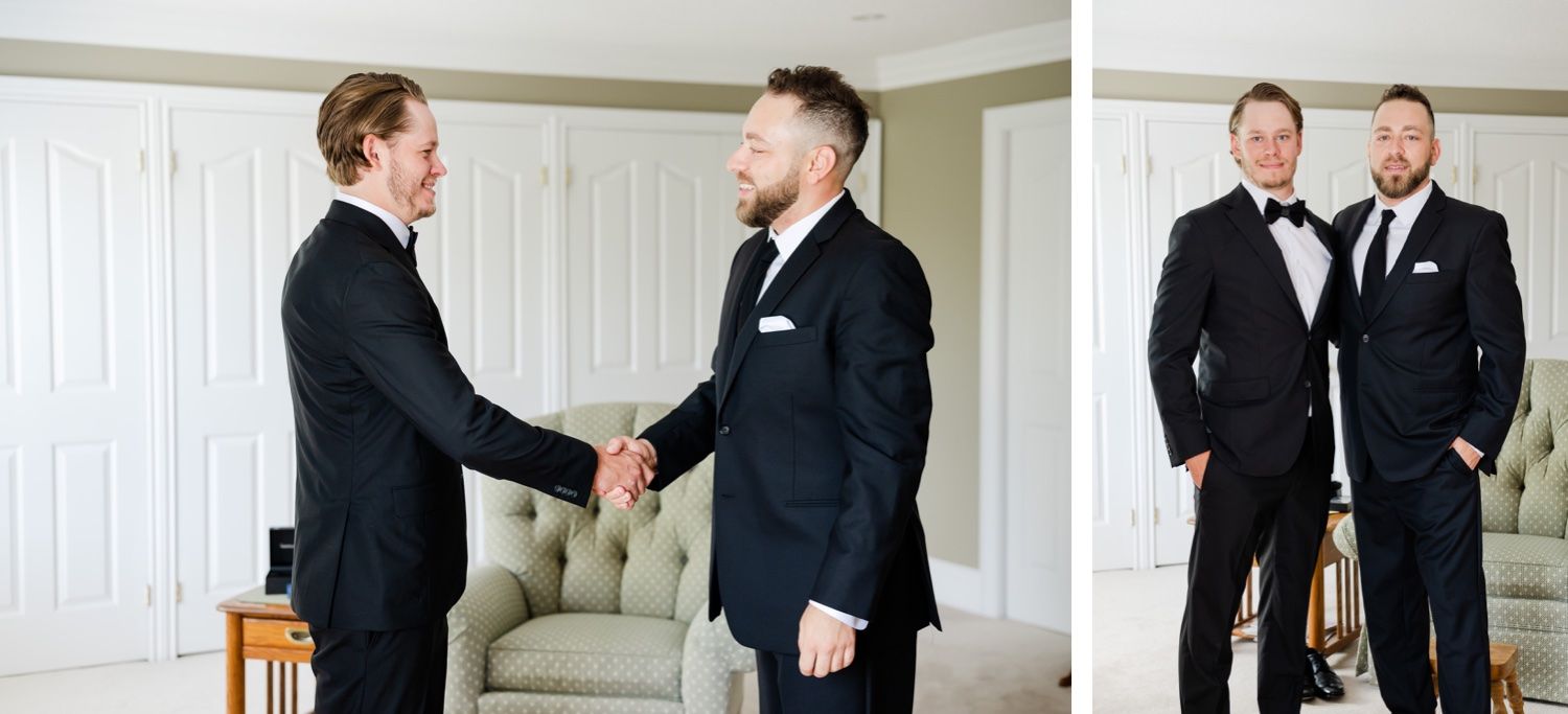 Two people in black tuxedos sharing a formal handshake and smiling.