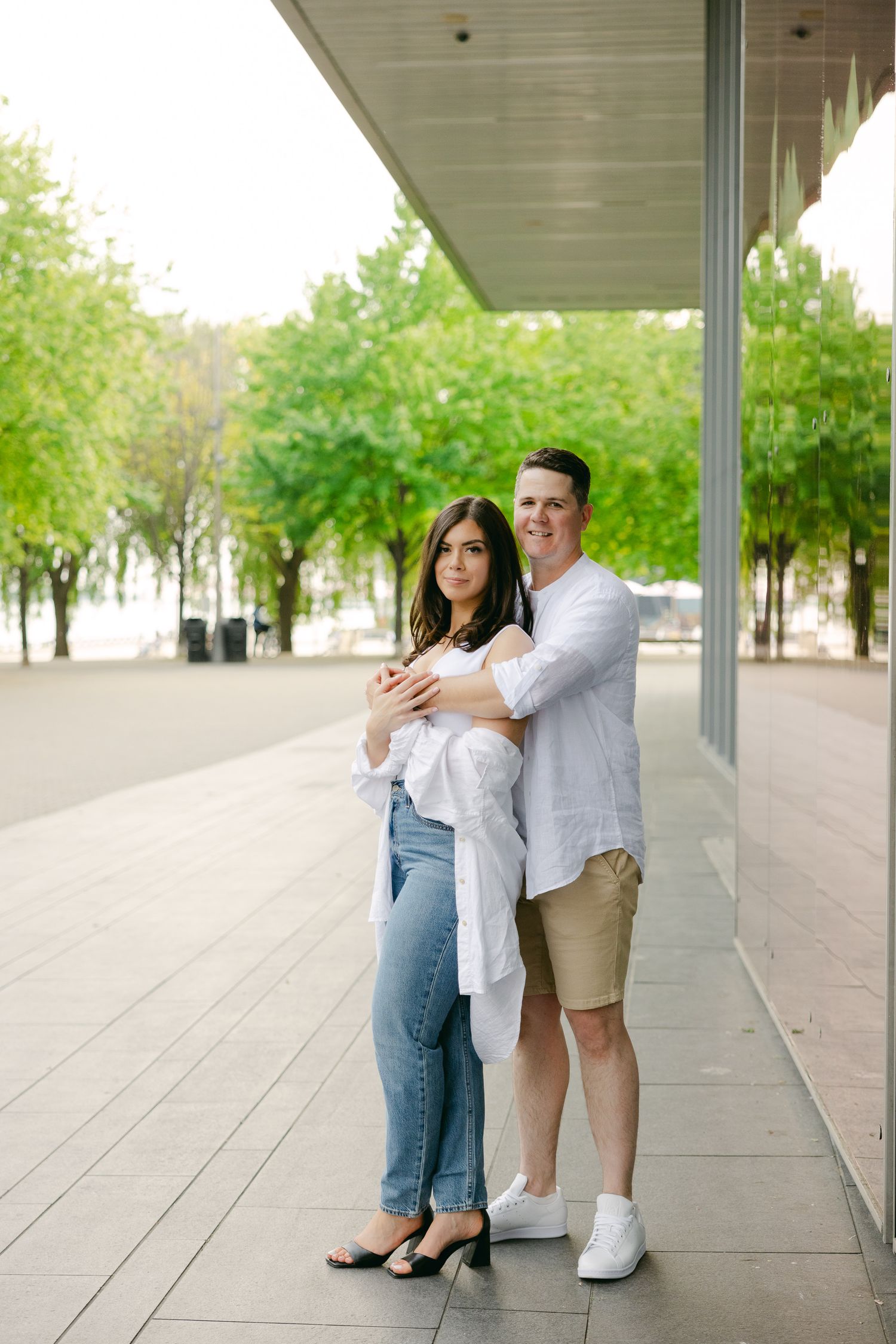A couple shares an intimate moment while standing in a covered outdoor walkway.
