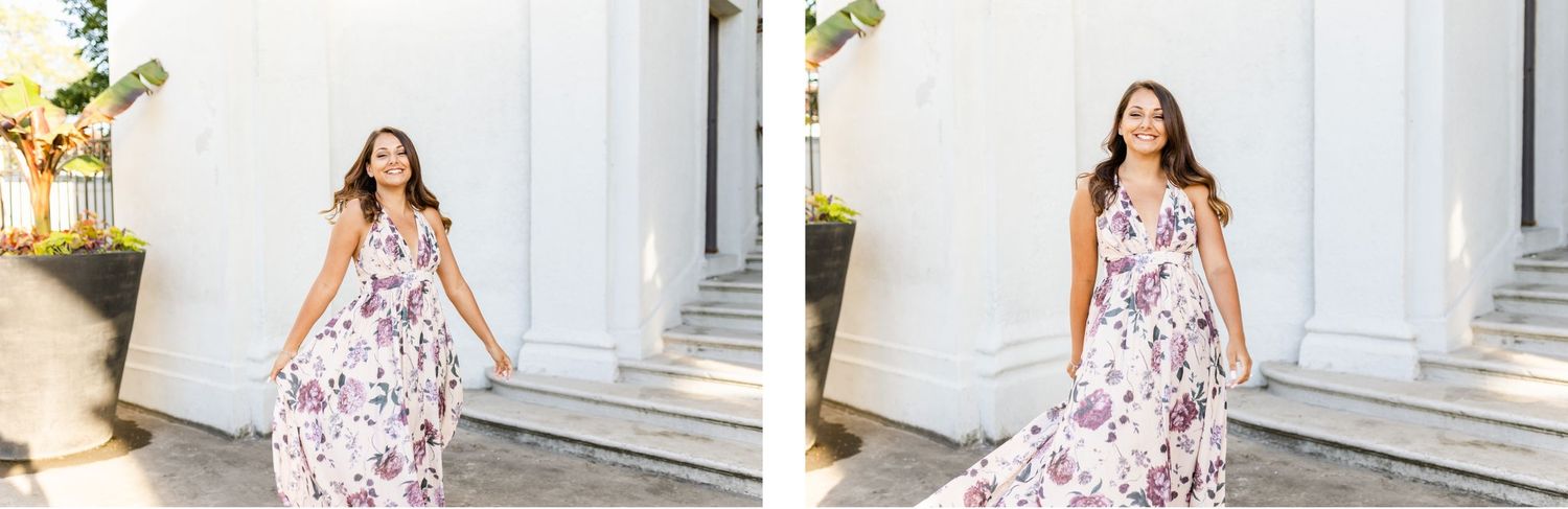 Woman in flowing floral maxi dress twirling on white stone porch.