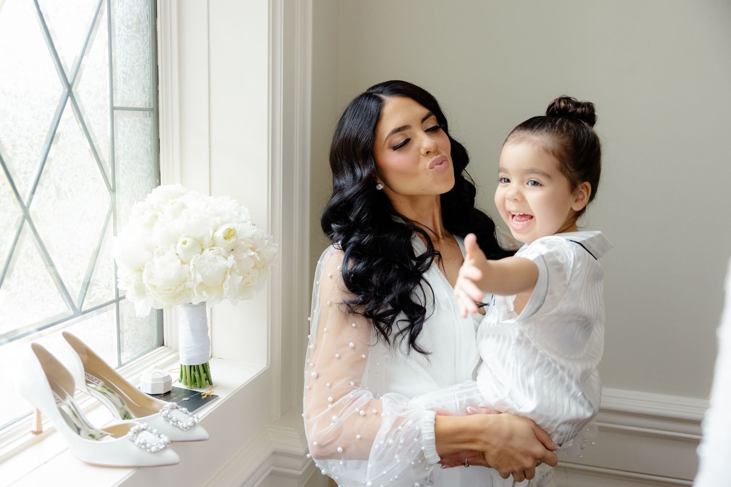 A joyful moment captured between parent and child next to a bouquet of white flowers.
