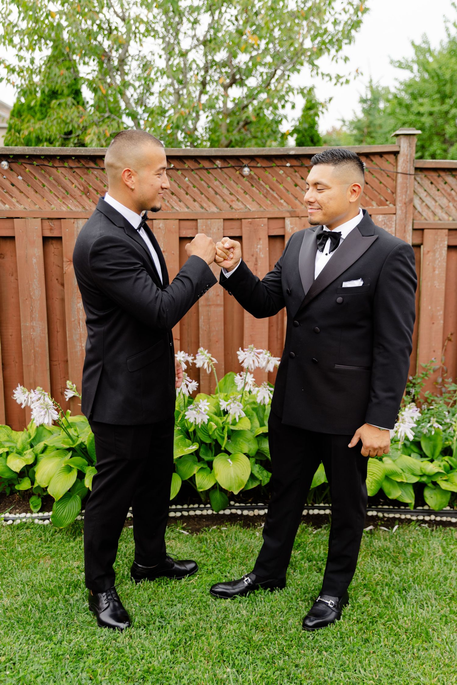 A playful series of groomsmen in black tuxedos performing dance moves on a lawn.