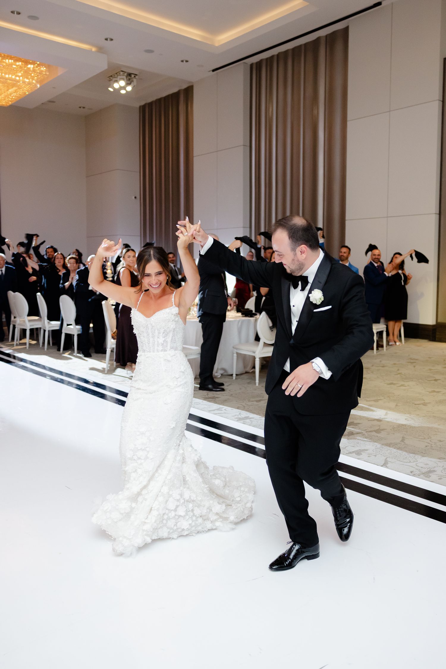Professional wedding photo sequence shows bride and groom practicing dance moves in an elegant ballroom setting.