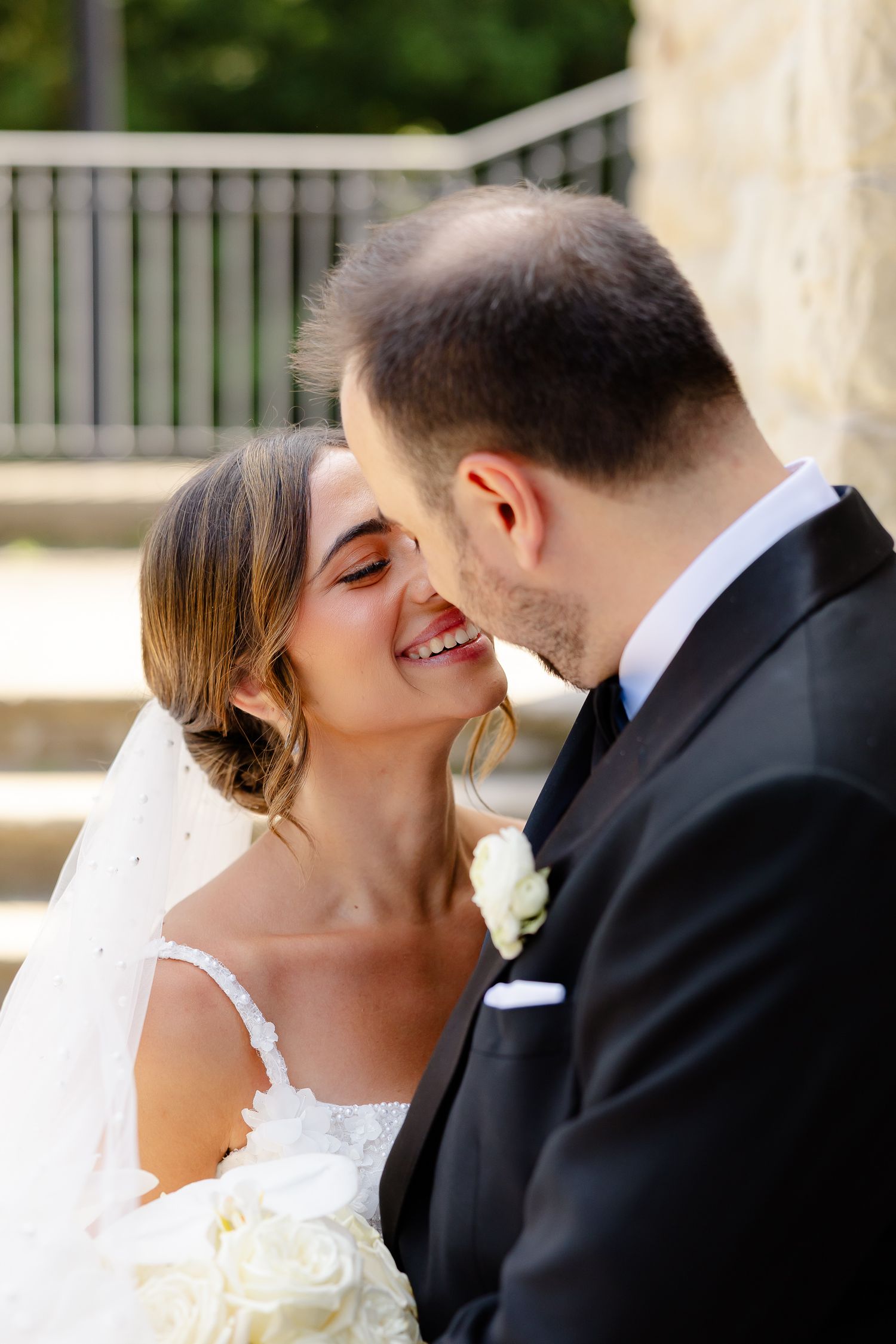 A romantic wedding couple kisses in a sequence of four similar photos captured outdoors.