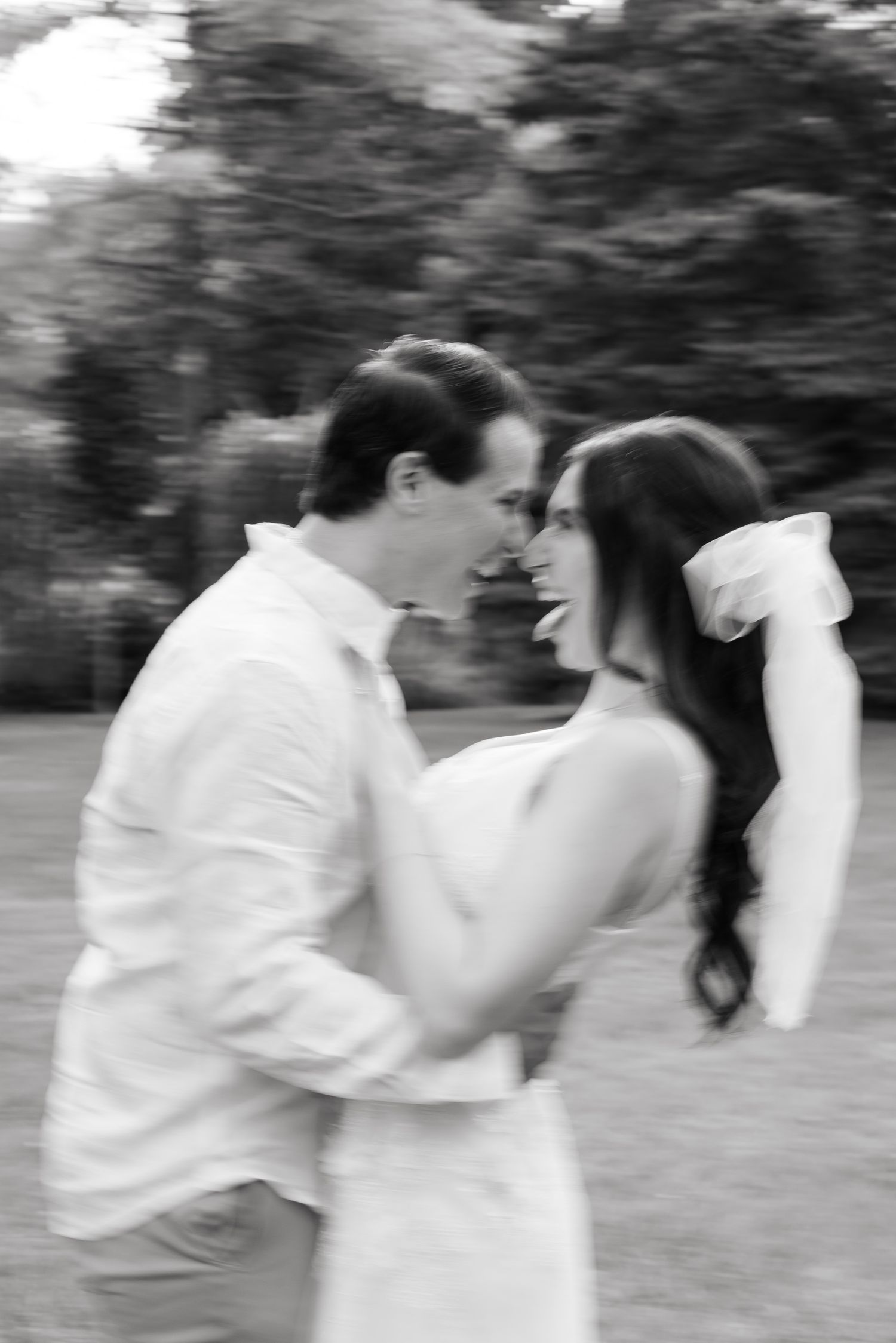 A blurred action shot showing a couple in white sharing a spontaneous dance moment.