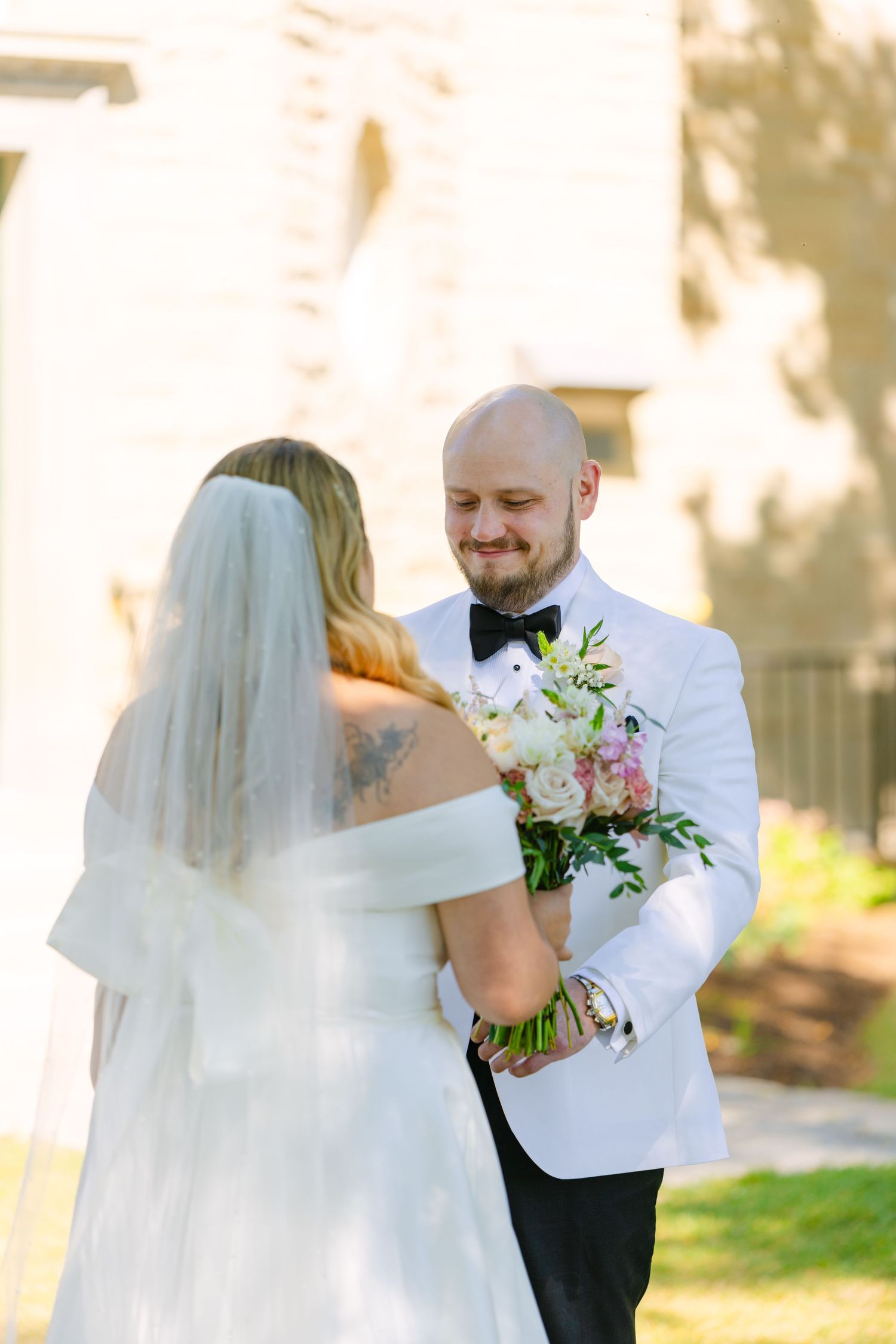 Black and white intimate wedding moment with couple embracing outdoors.