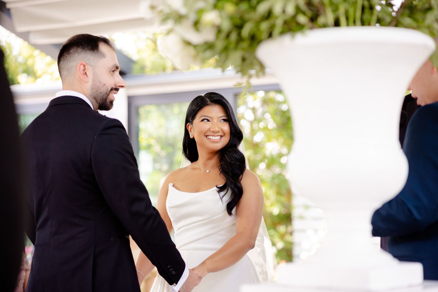 Wedding ceremony exchange of vows in a bright indoor venue with natural lighting.