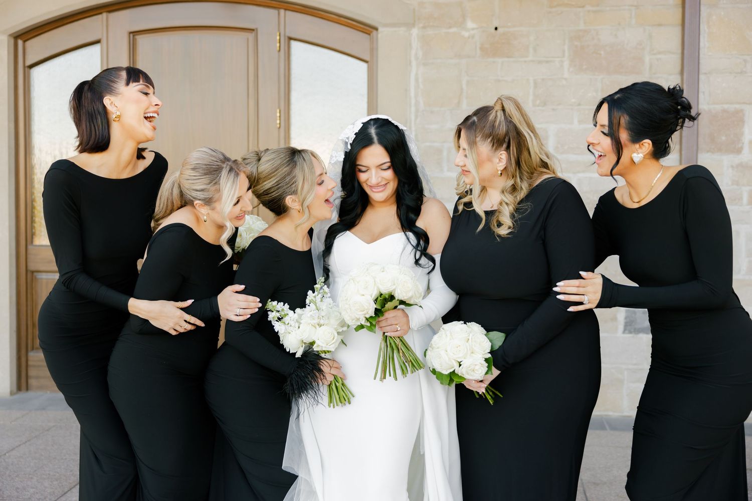 Wedding party shares joyful candid moment during outdoor photo session.