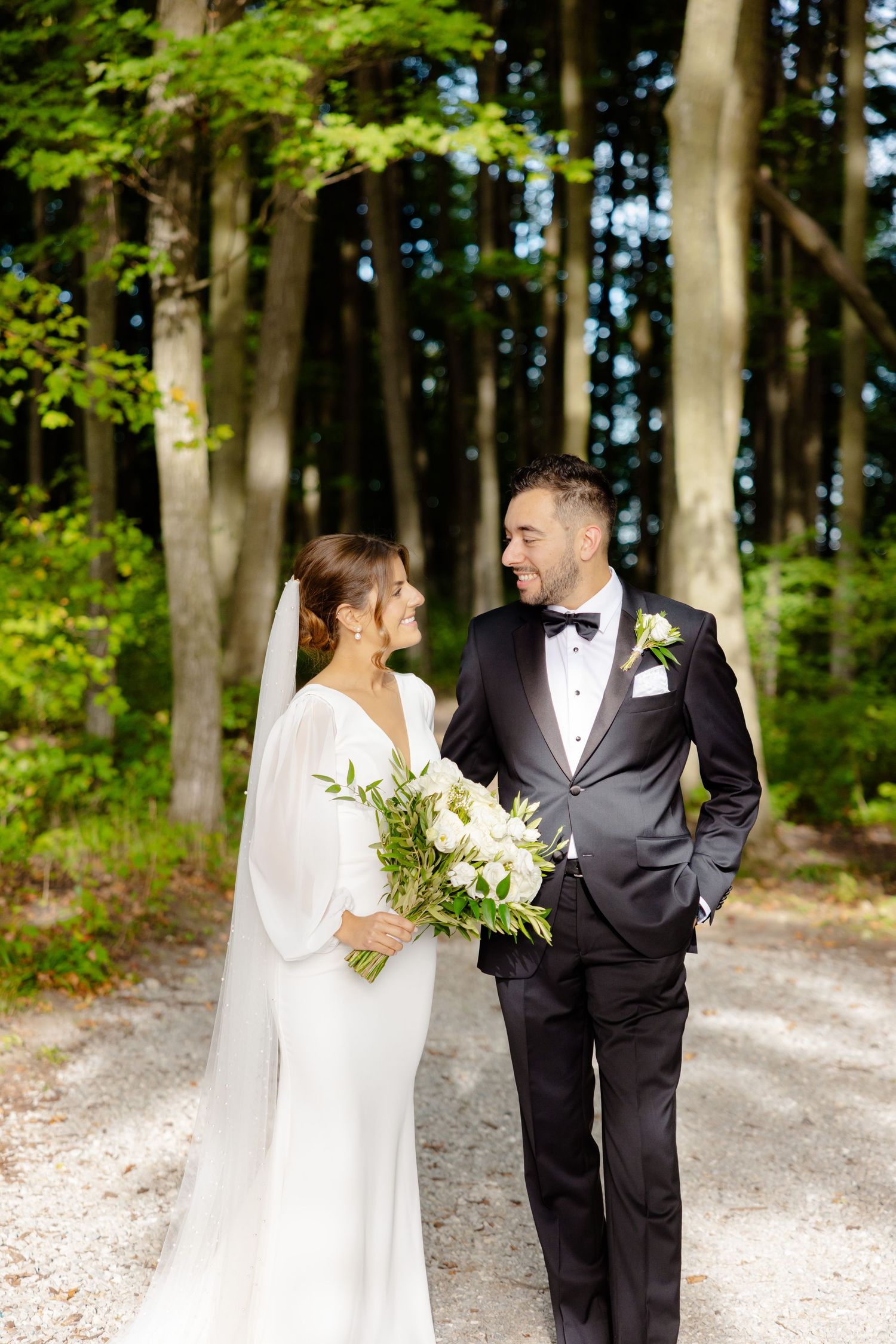 Happy couple shares intimate moment on woodland path during their wedding photoshoot.