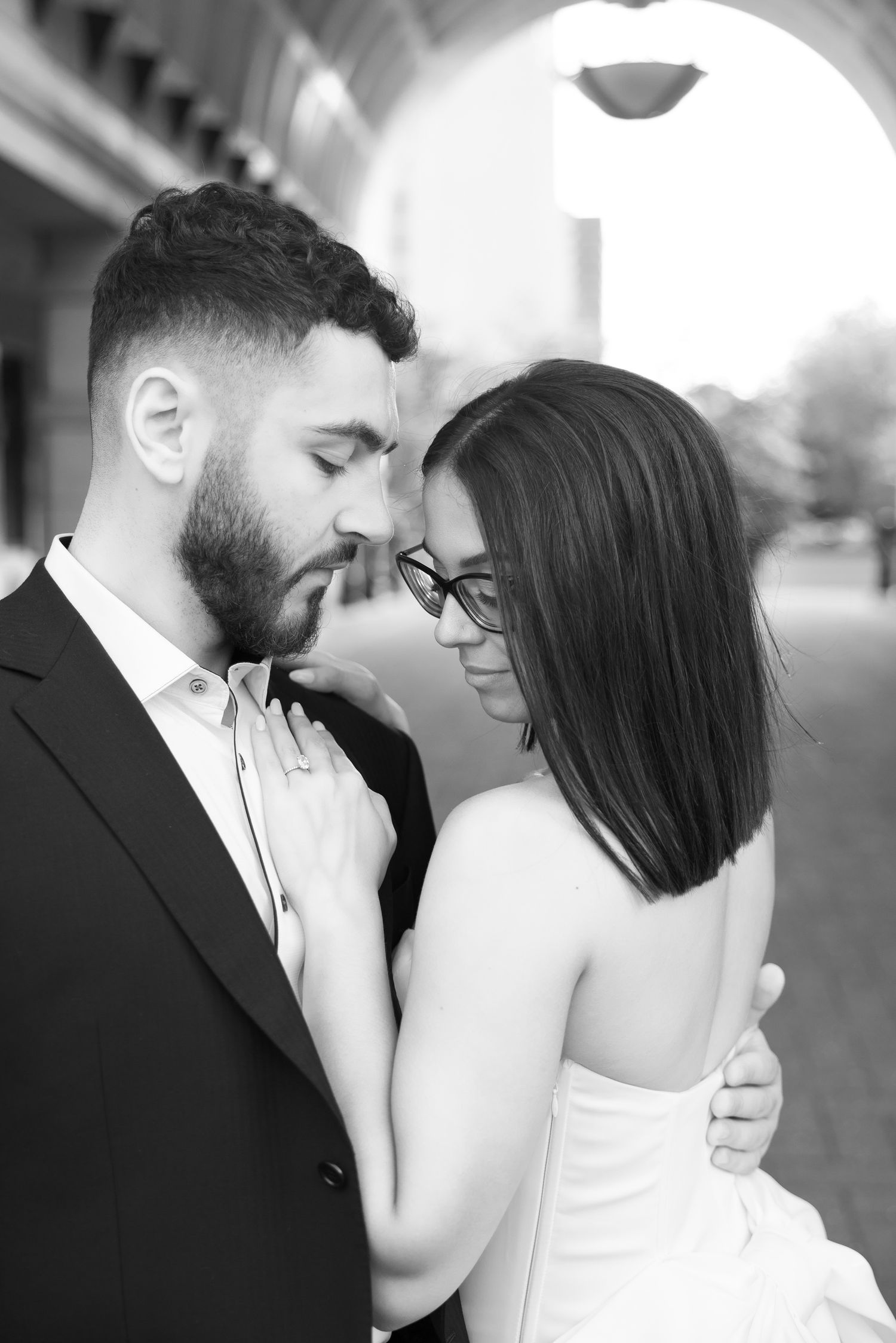 Black and white close-up of a couple sharing a tender moment in formal attire.