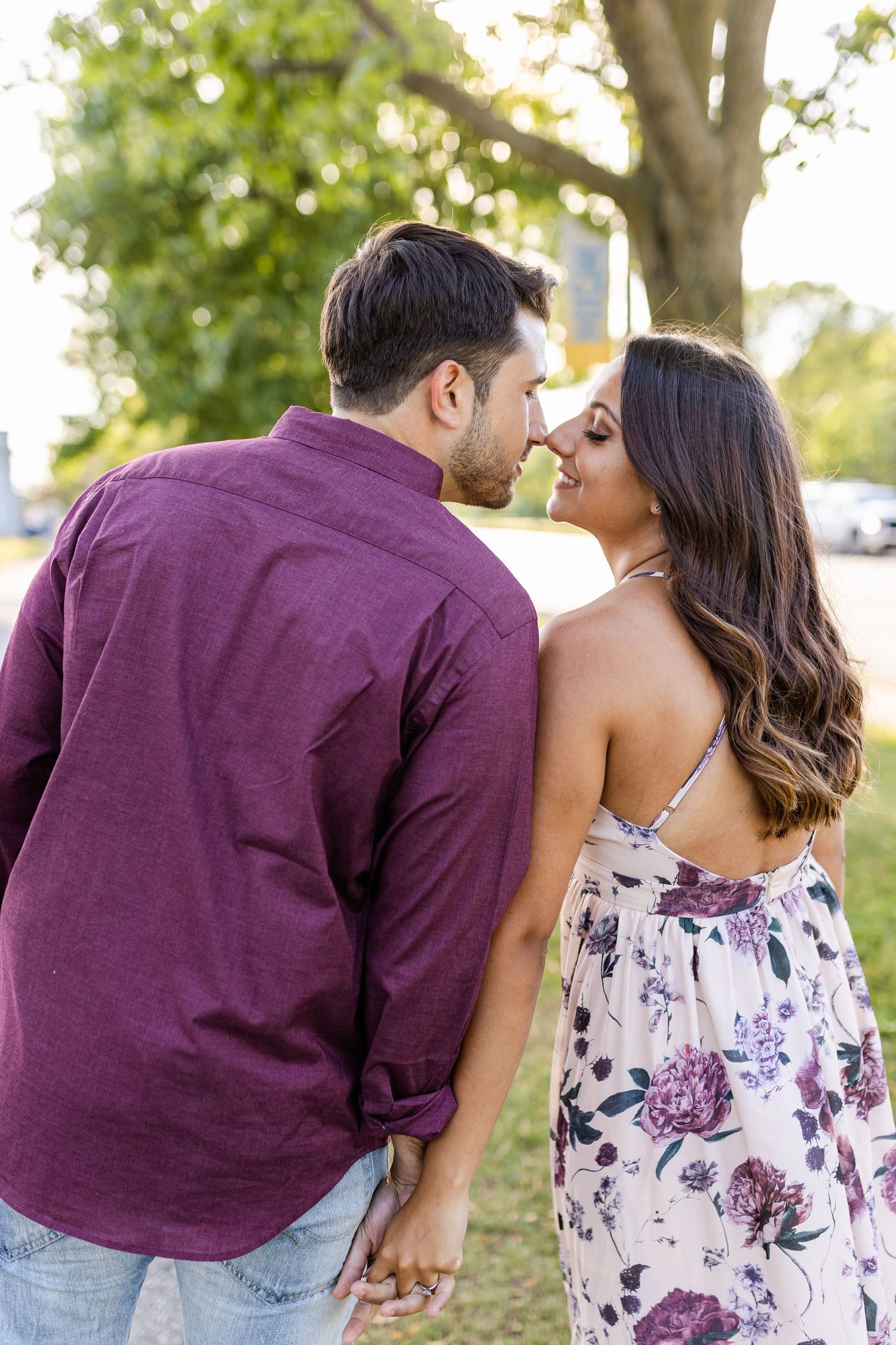 A couple sharing an intimate moment outdoors in casual attire.