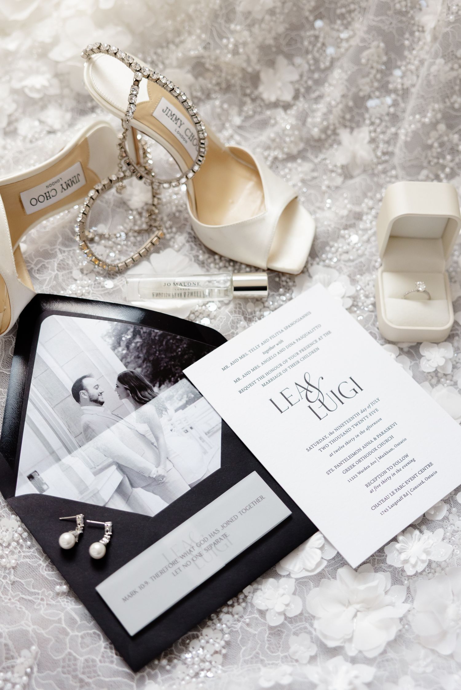Elegant wedding details including white invitation, bridal shoes, jewelry and ring box on lace background.