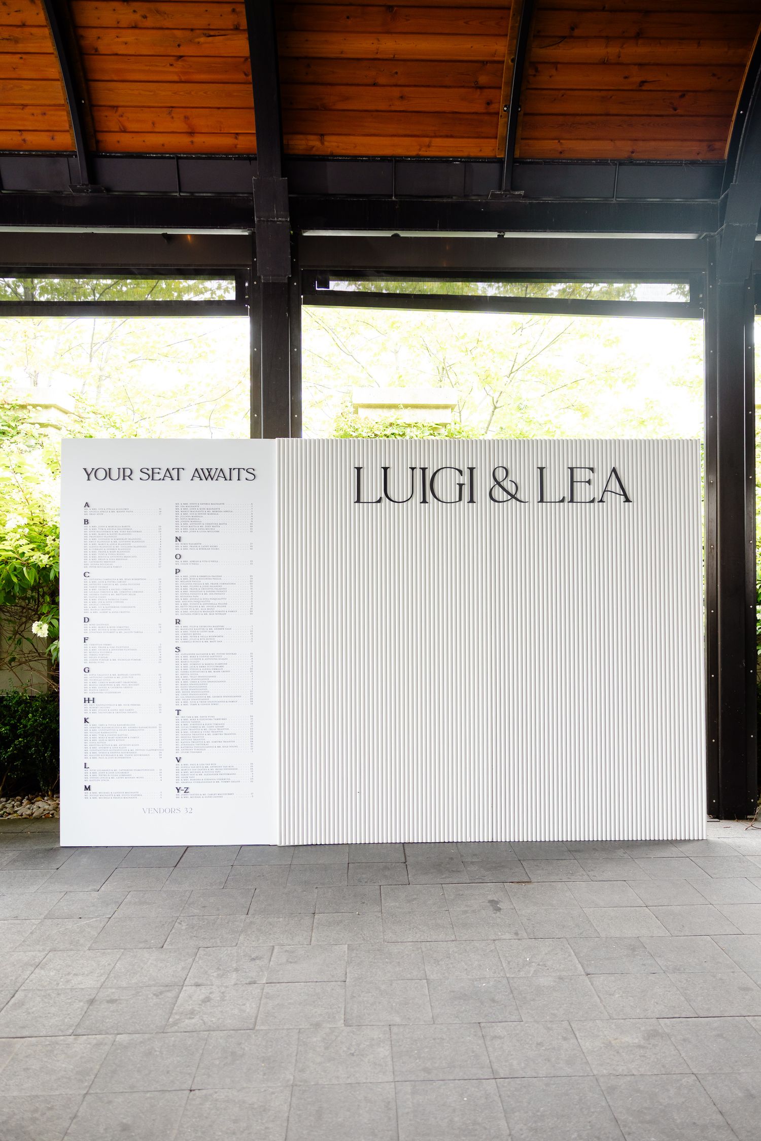White wall with seating charts or menu boards mounted in what appears to be a restaurant or venue entrance area.