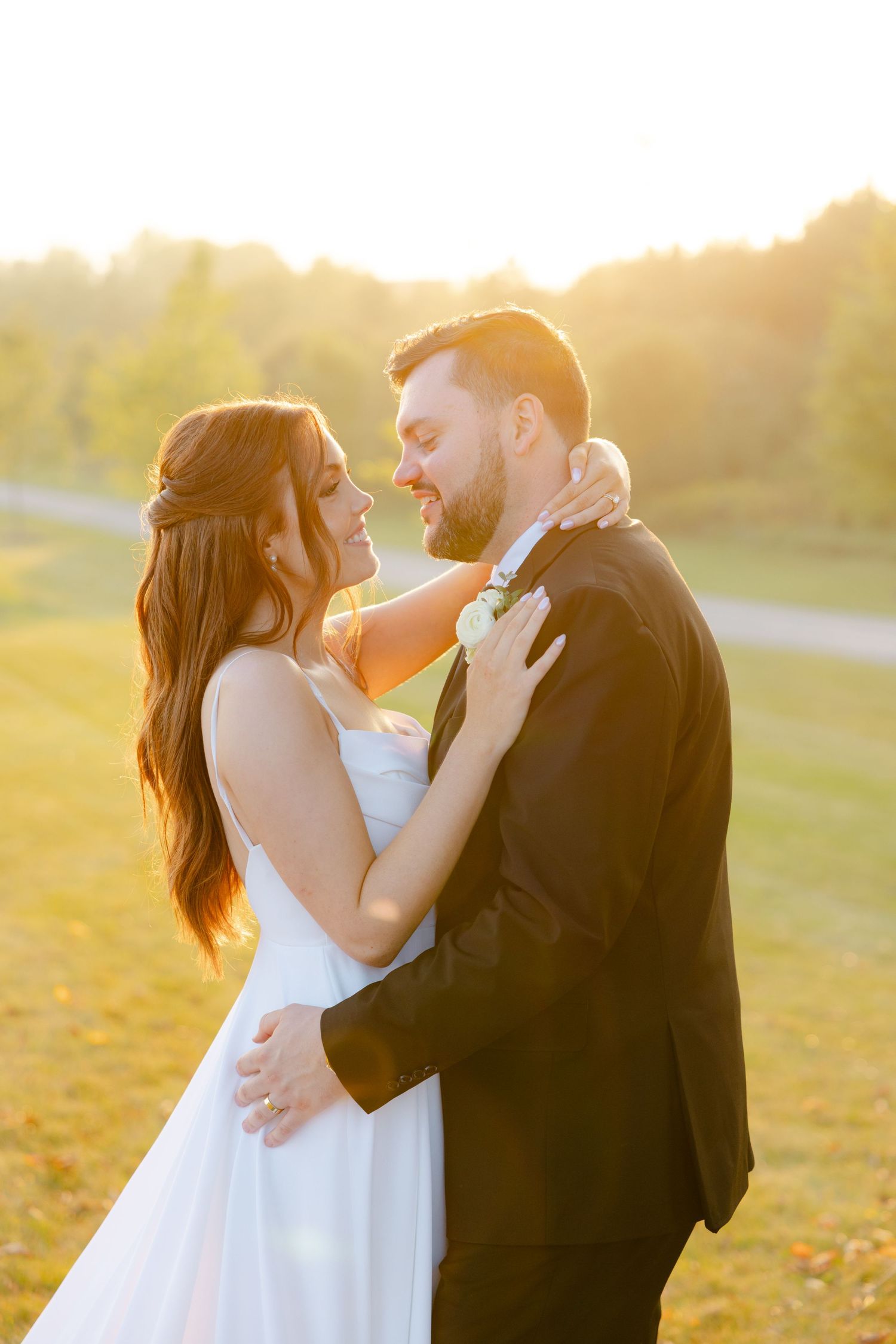 Wedding couple shares a tender moment during sunset photography session in a natural outdoor setting.