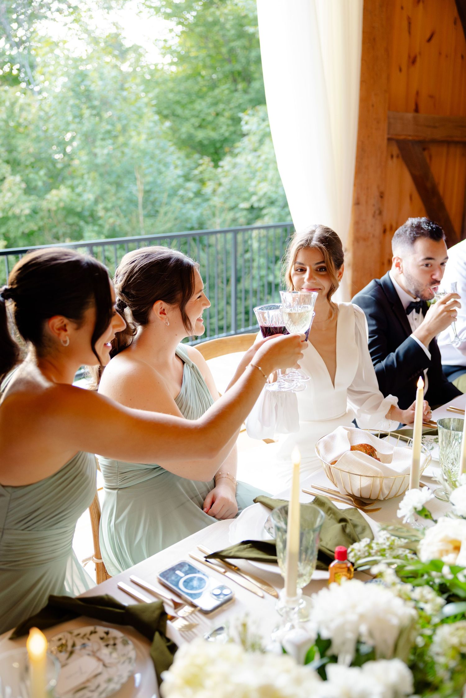 Wedding party toasting at an elegant reception table with floral decorations.
