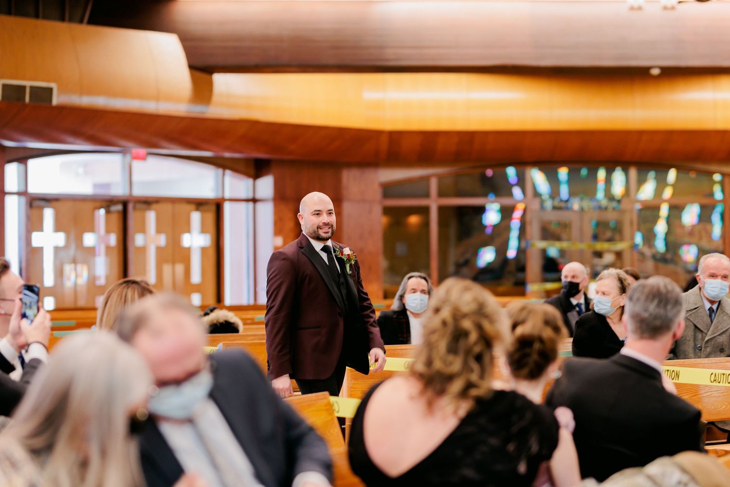 Wedding reception speech in wood-paneled room with audience seated at tables.