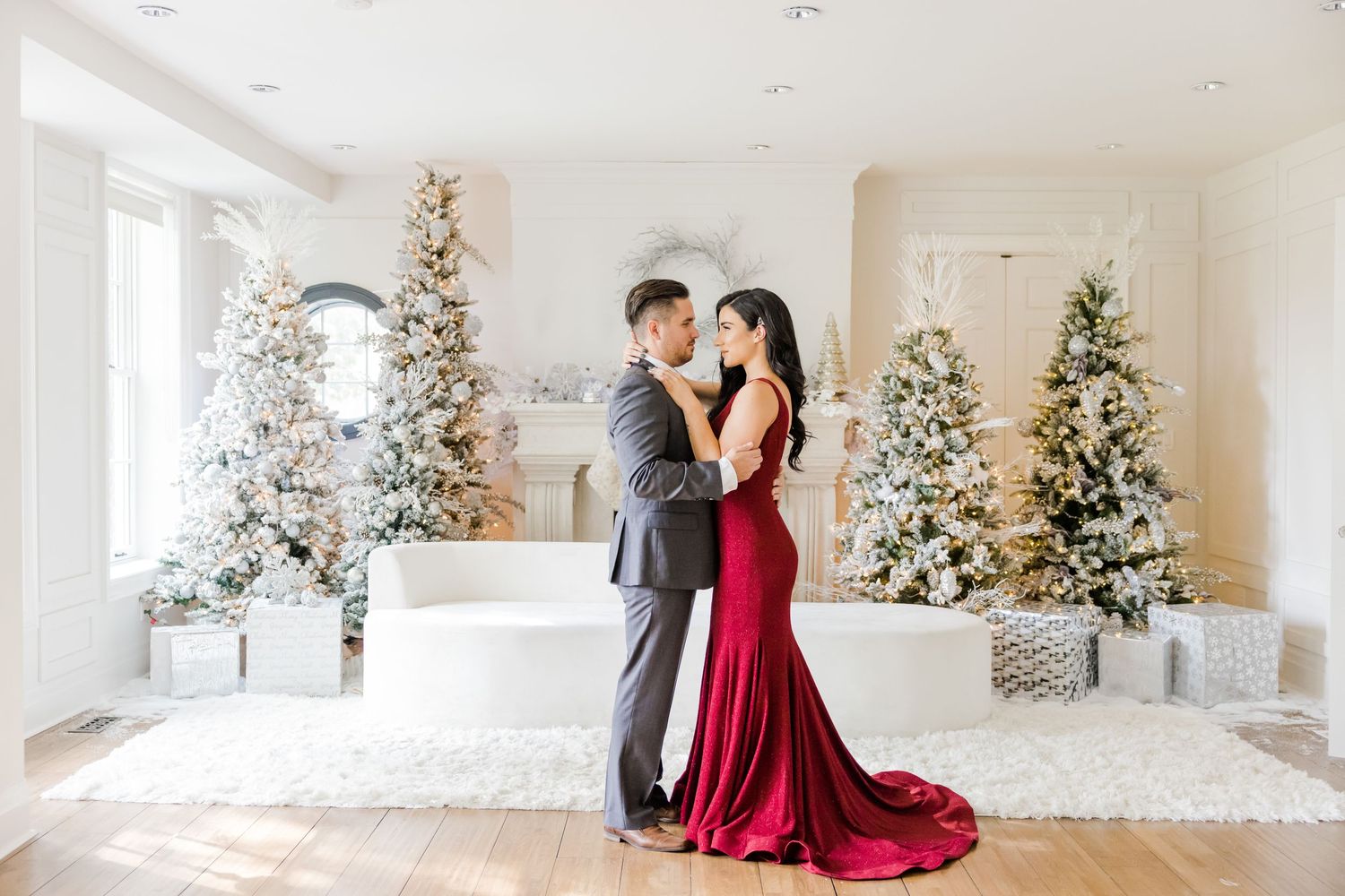 Elegant winter holiday scene with decorated Christmas trees and couple in formal attire.