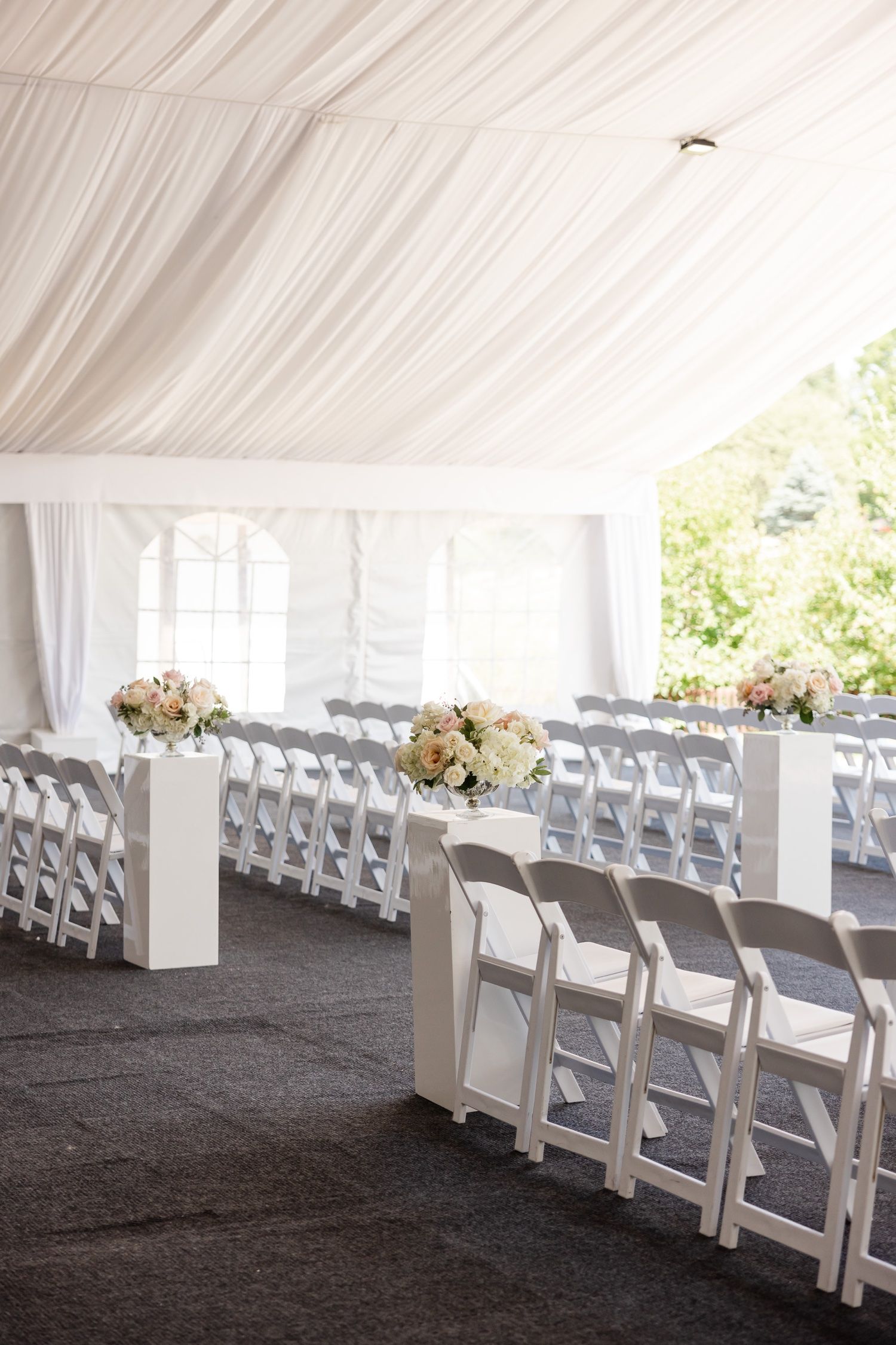 Wedding reception venue with elegant white draping and folding chairs arranged in neat rows.