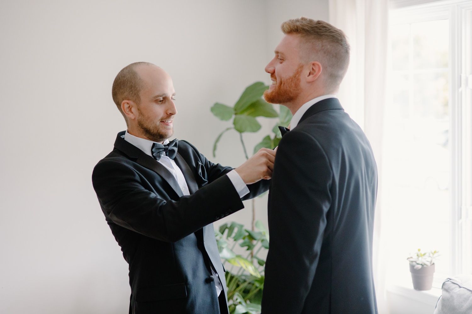 Two people in formal attire interact during a pre-event preparation.