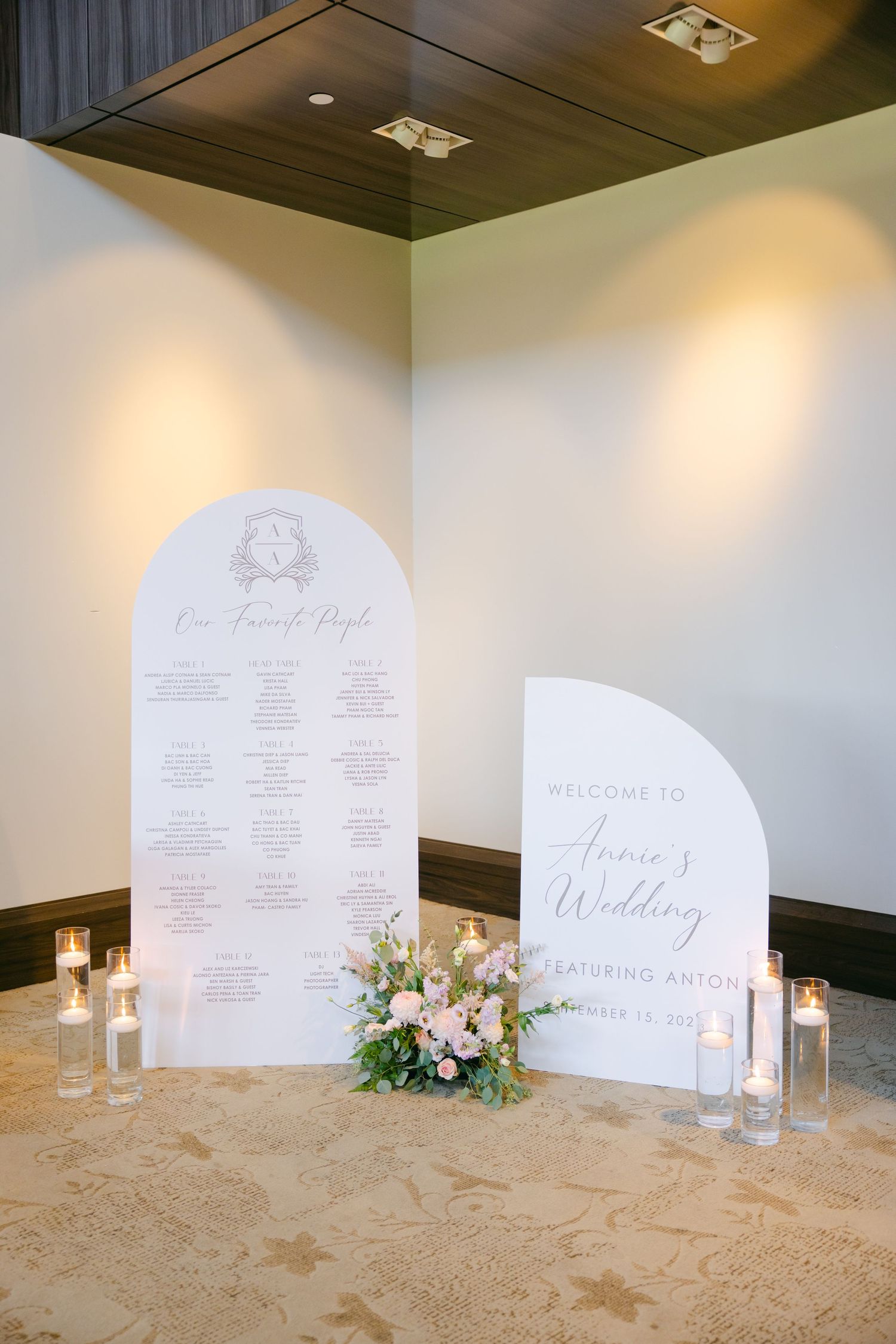 Elegant wedding seating chart and welcome display with soft floral arrangements and glowing candles.