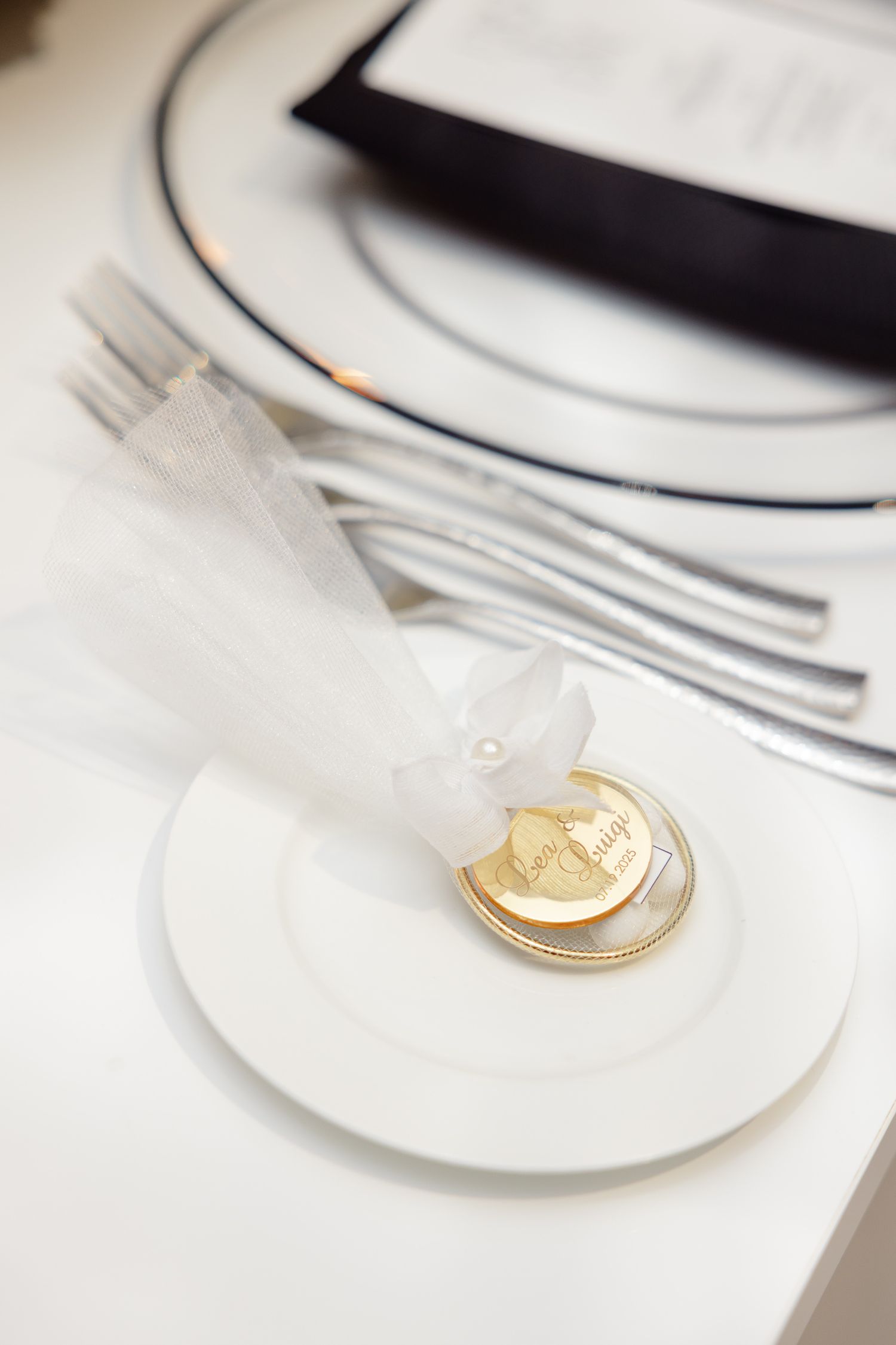 Clean white restaurant place setting with elegant silverware and dinnerware arranged on table.