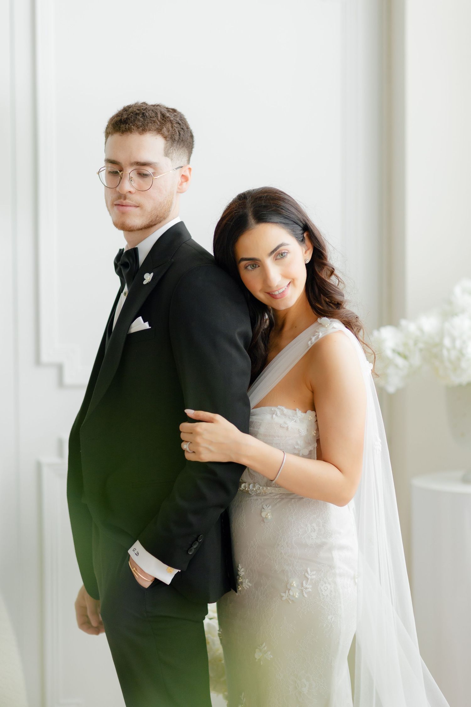 A sophisticated wedding portrait featuring a couple in classic black and white attire.