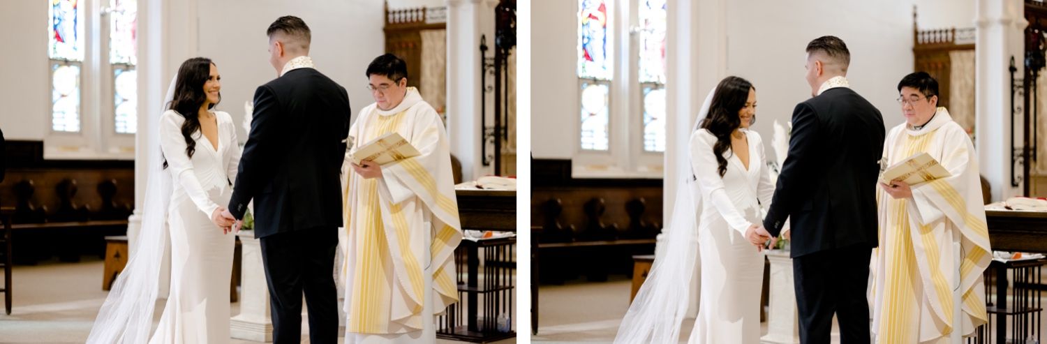 A couple exchanges vows during their wedding ceremony in a church sanctuary with stained glass windows.
