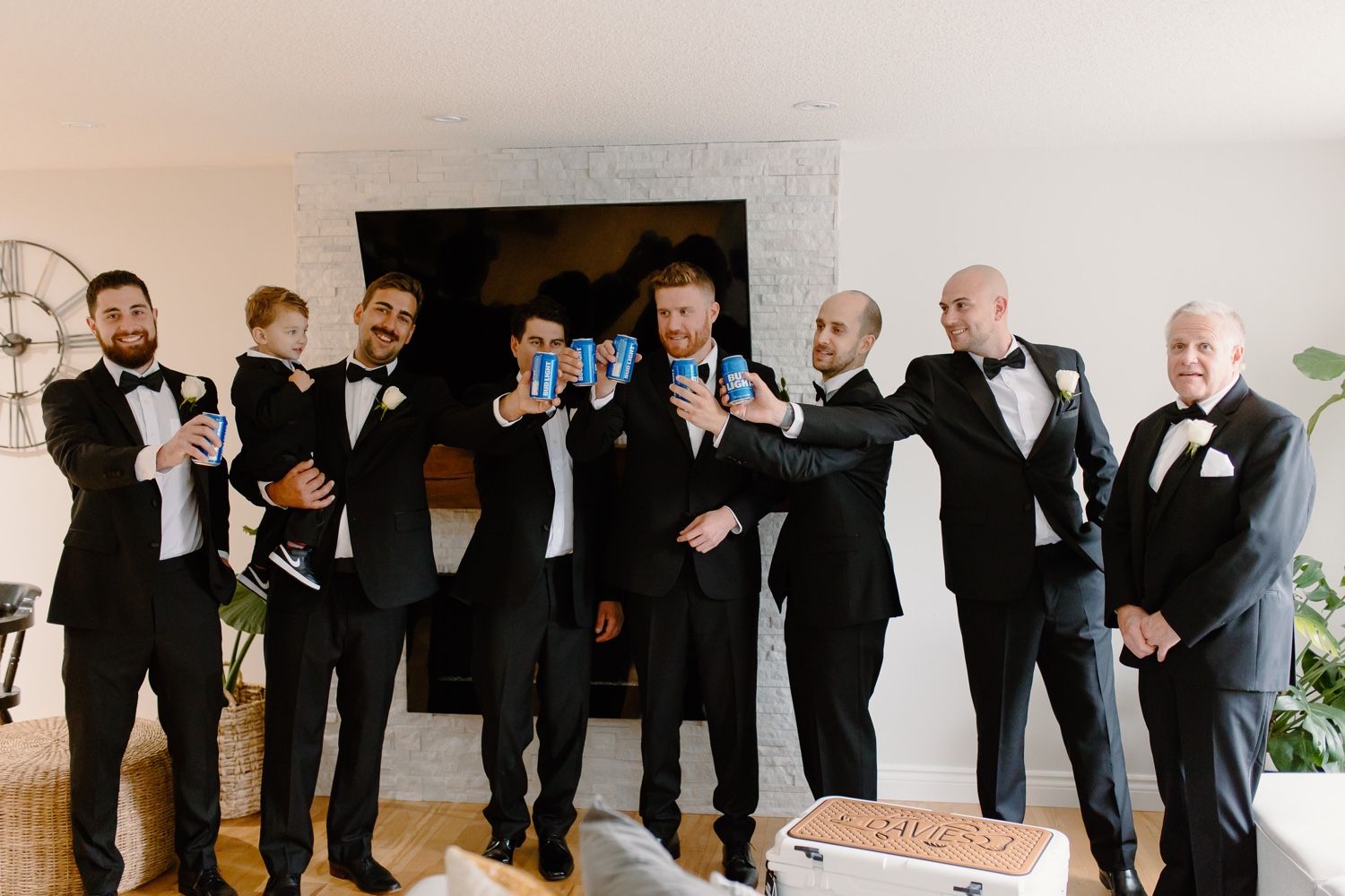 Group in formal black tie attire poses together for celebratory photo.
