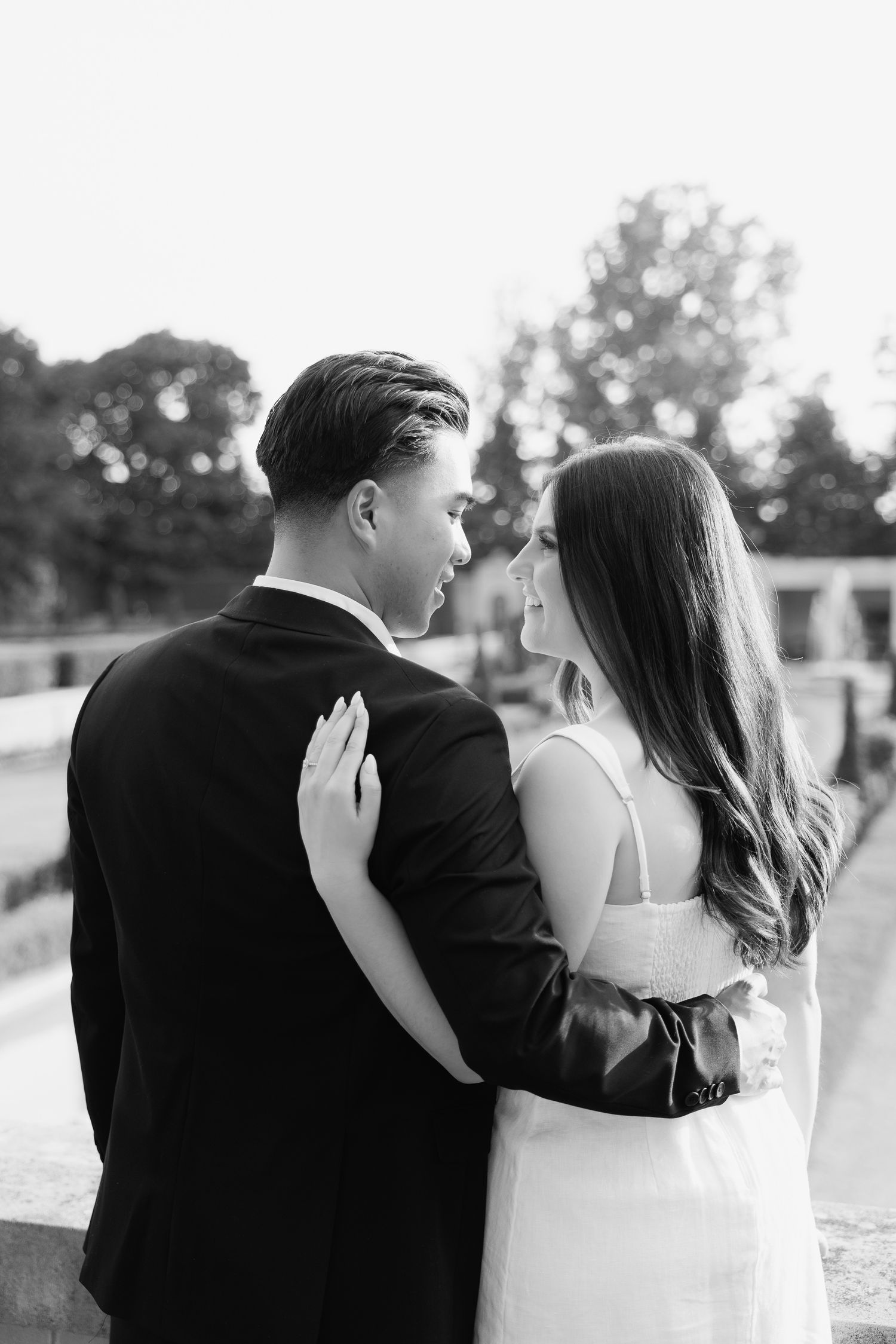 An intimate black and white portrait of a couple embracing on a grand terrace.