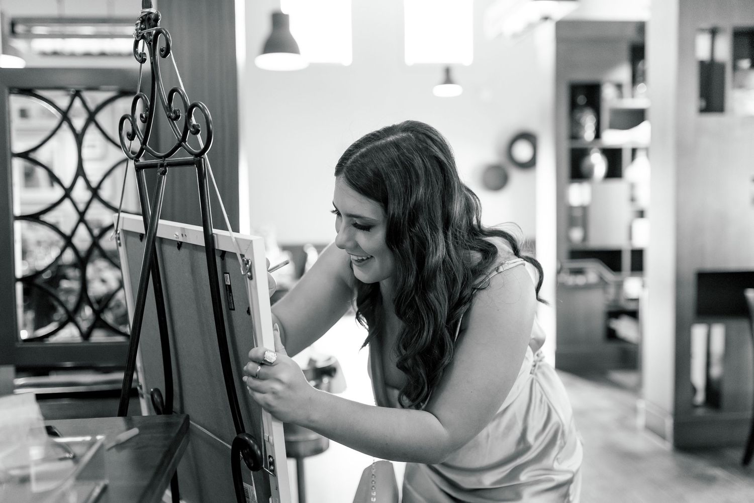 A person in a white dress writing on a board during a special event preparation.