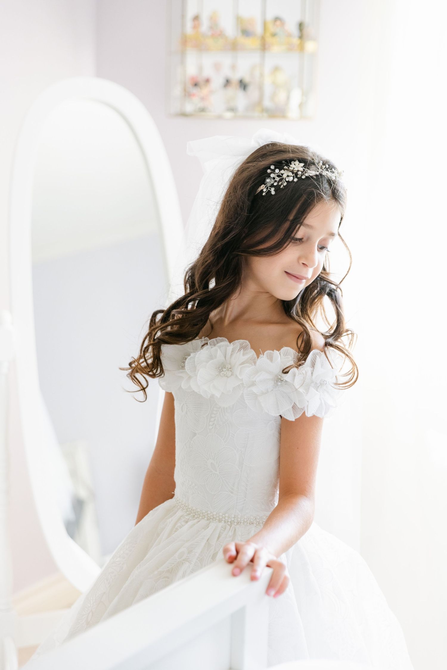Elegant white dress with delicate floral details captured in soft natural light.