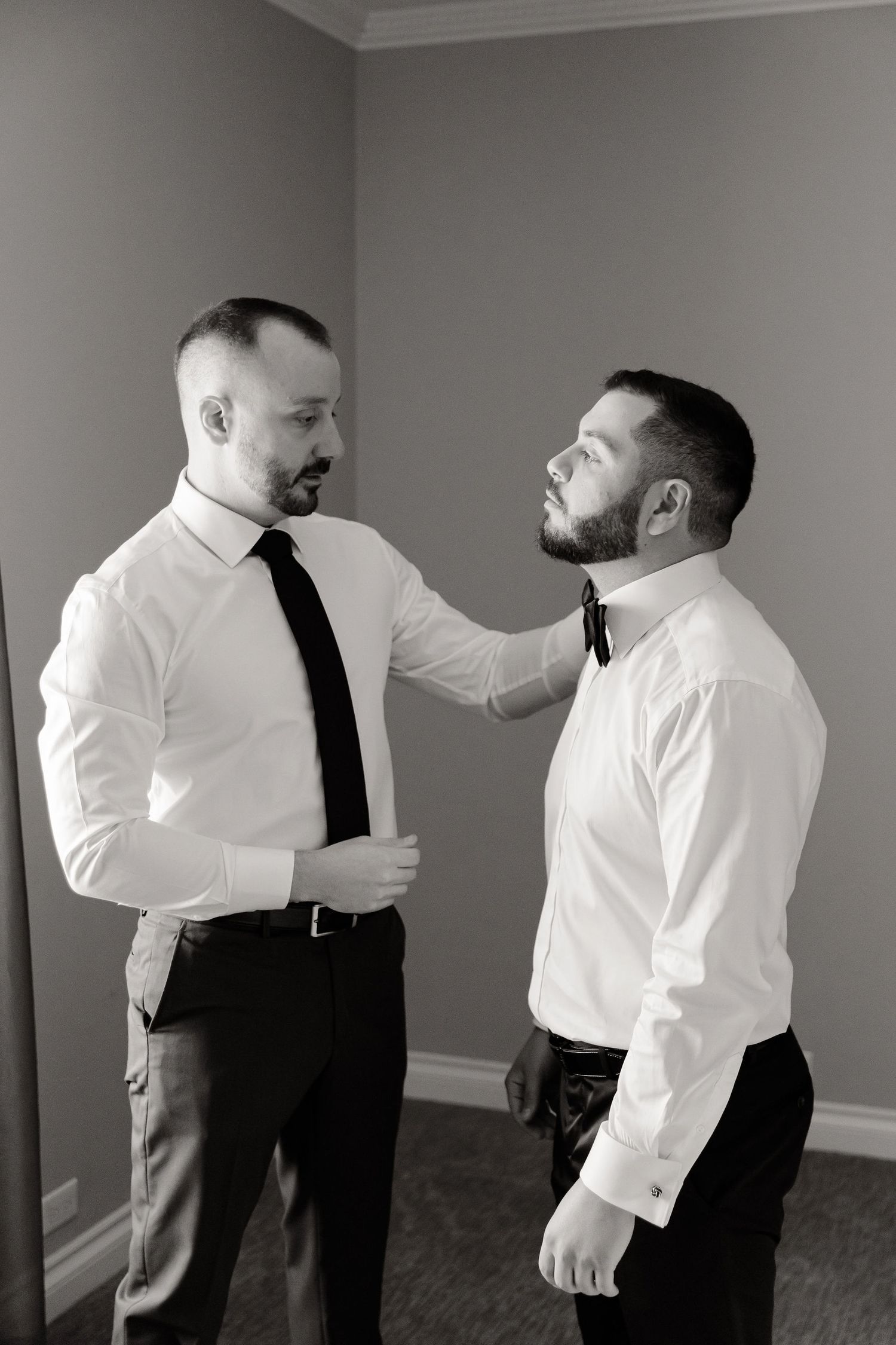 A sequence of candid moments showing two formally dressed individuals interacting in a grey-walled room.