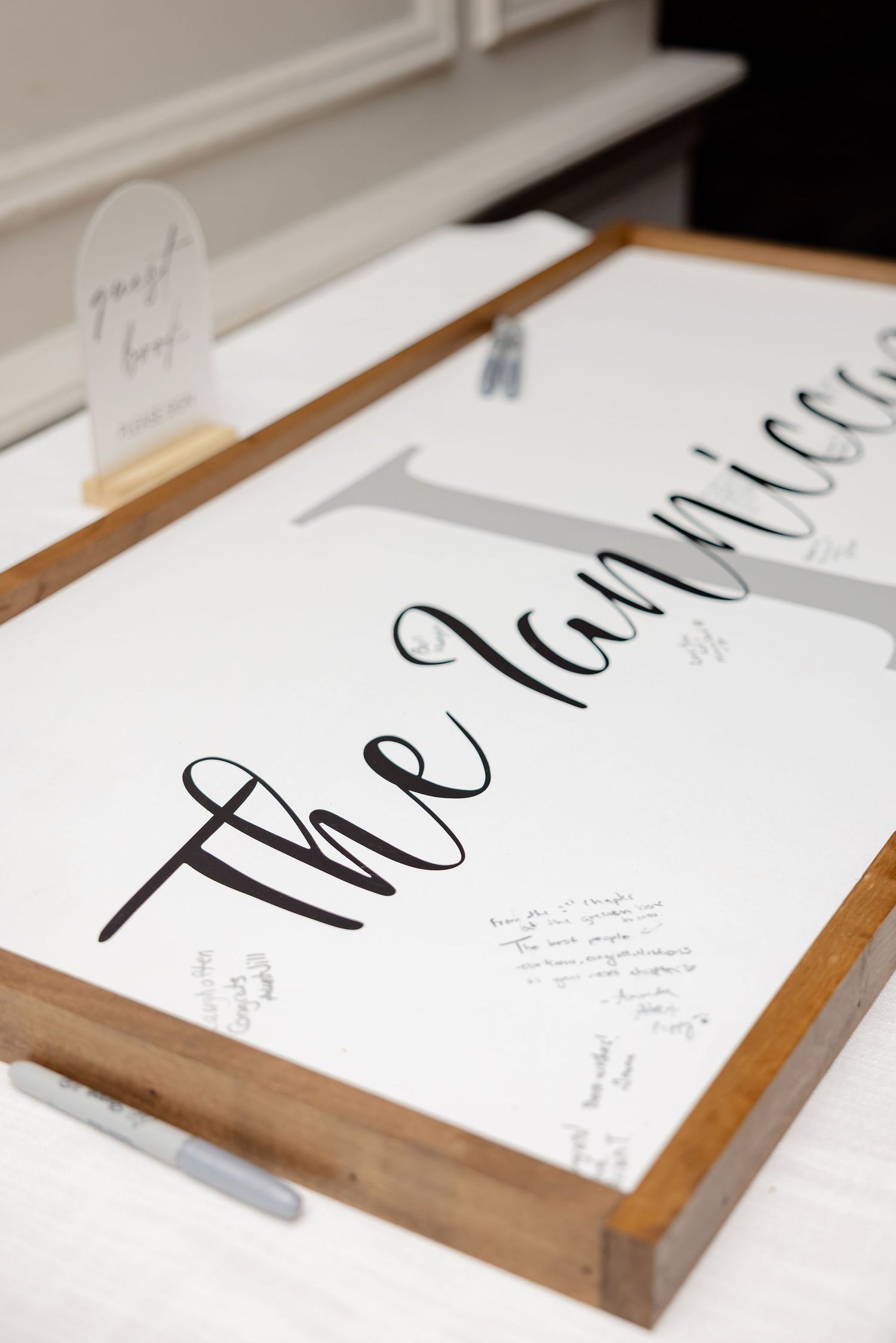 Modern calligraphy wedding signage with 'thank you' text displayed on a wooden holder.