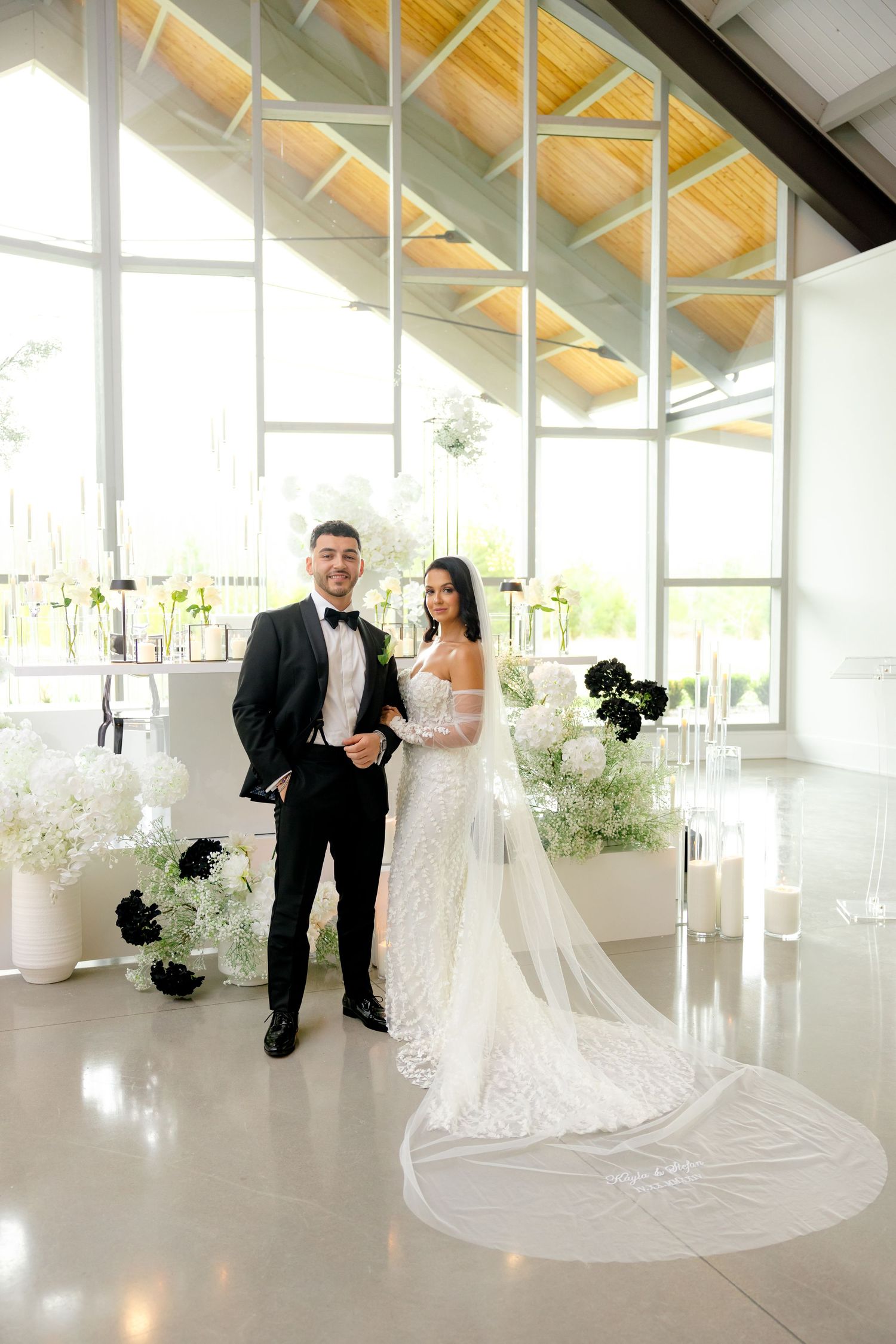 Modern wedding venue with dramatic vaulted ceilings, floor-to-ceiling windows, and elegant decor.