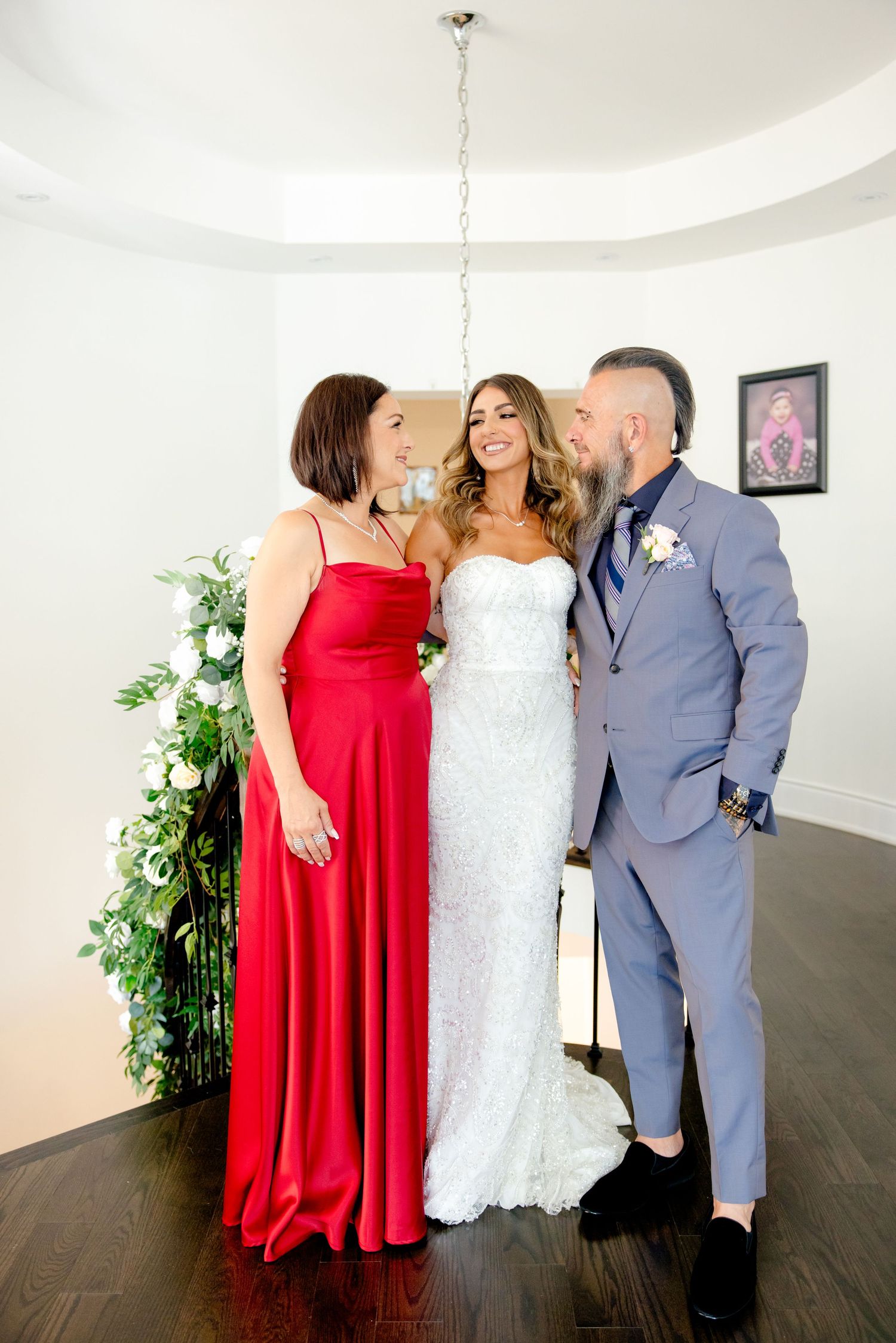Candid wedding moment showing joyful interaction between bride, bridesmaid and groomsman.