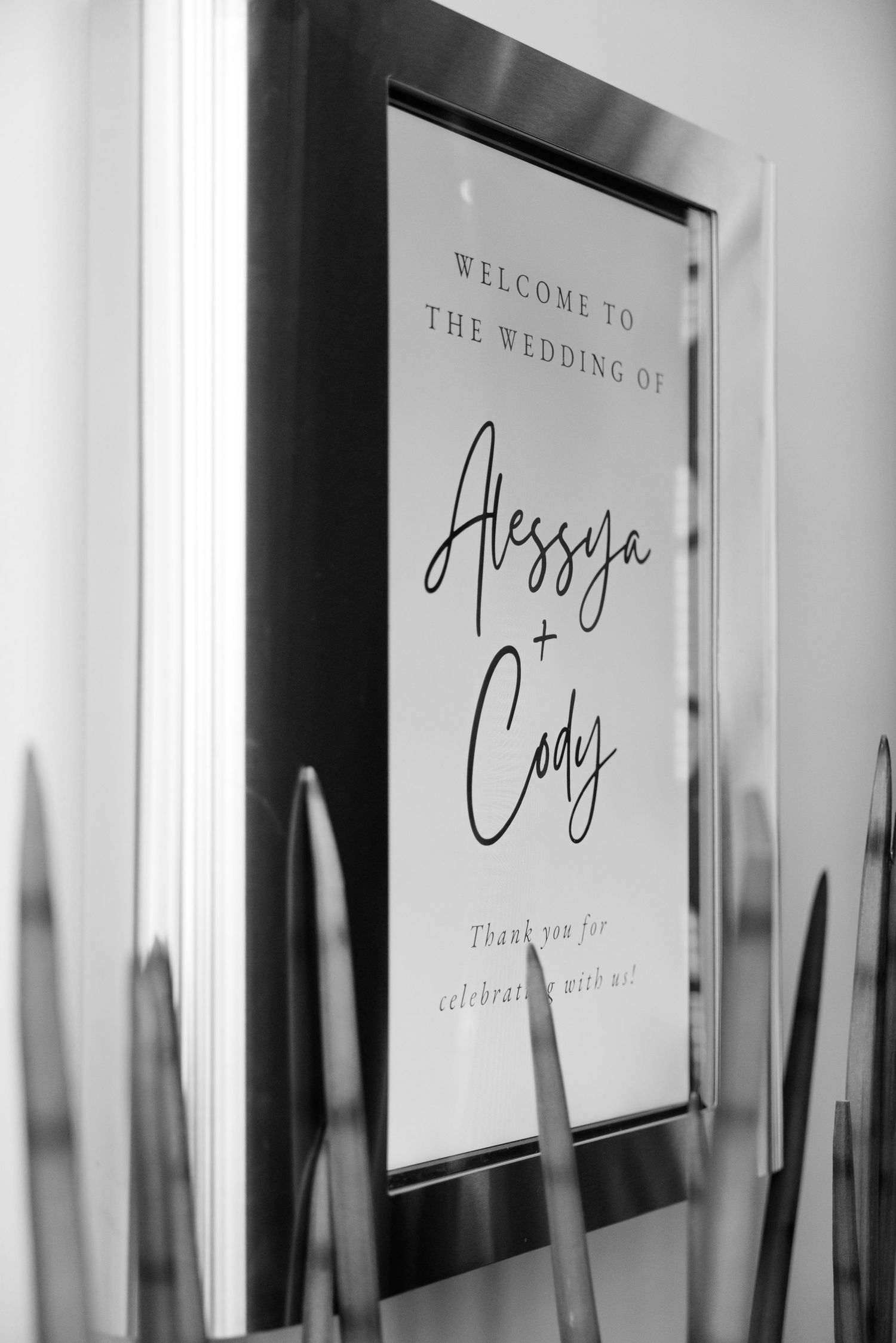 A black and white wedding welcome sign displayed in an elegant frame.