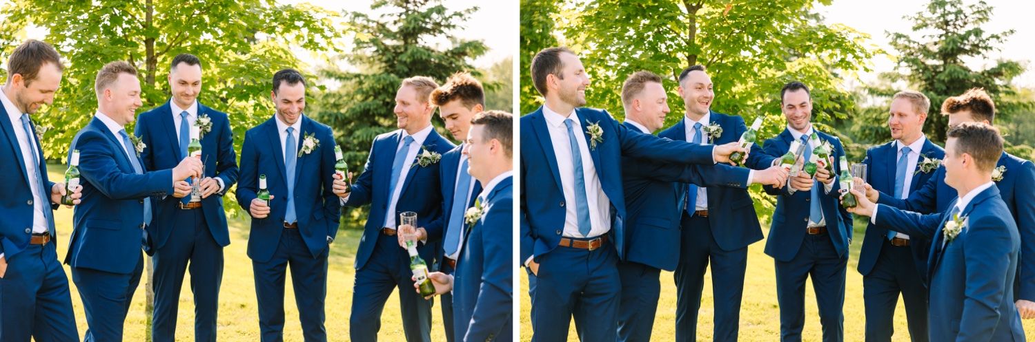 Groomsmen in navy suits share laughs during outdoor wedding photo session.