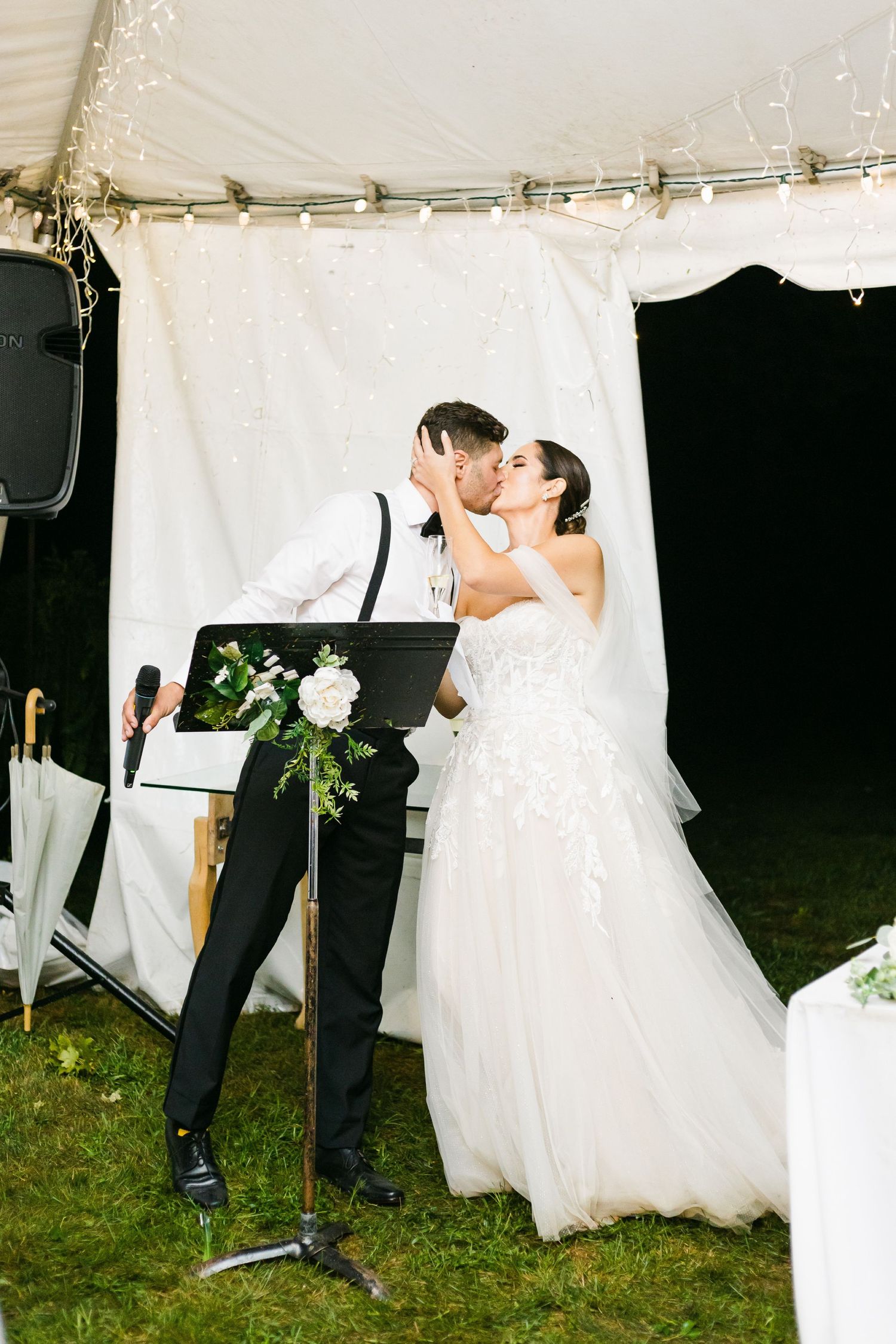 Wedding couple sharing a romantic moment near a display at their reception.